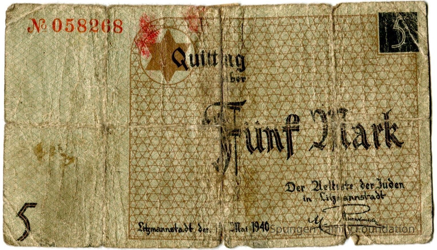 1940 May 15, Front side - Scrip worth 5-marks from Łódź (Litzmannstadt) Jewish ghetto.: Tan paper with printed text, outline, and illustration in green, brown, red, and black ink. At the top left corner, a serial number, "No 058268" printed in red ink. At the bottom left, the number "5" printed in black ink. At the center, the Star of David printed in brown ink. A repetitive triangular pattern appears at the right side in brown ink. Overtop, text in black ink reads, "Quittung / uber / Fünf Mark". At the bottom right, a printed signature in black ink. Overtop the tan paper, a green patterned background is printed.