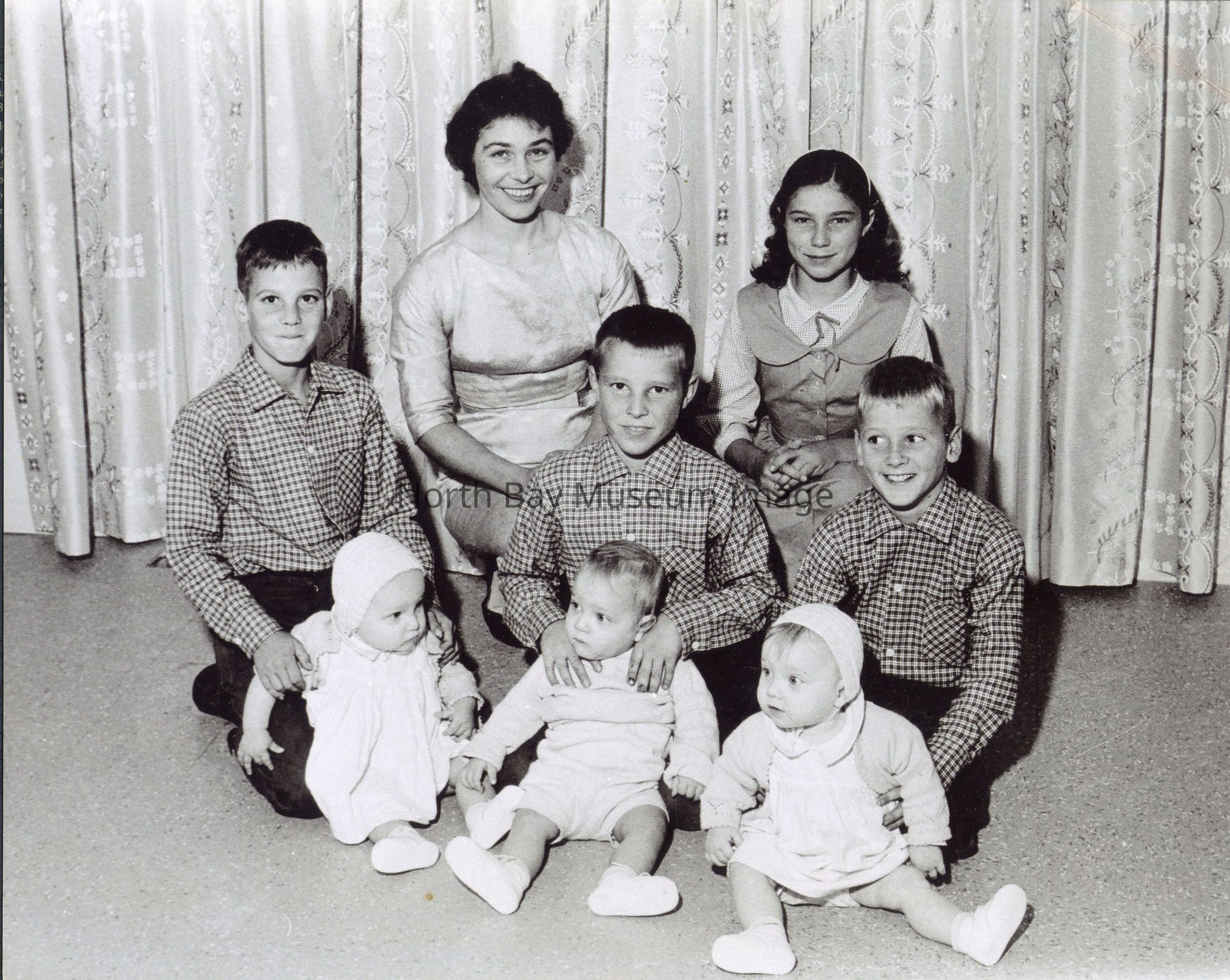 2025.01.007: A Nugget photo taken to showcase the Rousseau's upcoming open house to celebrate the new home built for the family by the North Bay and District Junior Chamber of Commerce with the help of local businesses, institutions, neighbours and friends. Front from left, Geraldine, Garry, and Corinne about to turn 1. Middle from left, Daniel, Steven, 9, and David (Daniel & David 10 year old twins). Back from left, the mother Birdie Rousseau, 29, and daughter Janie, 11.
