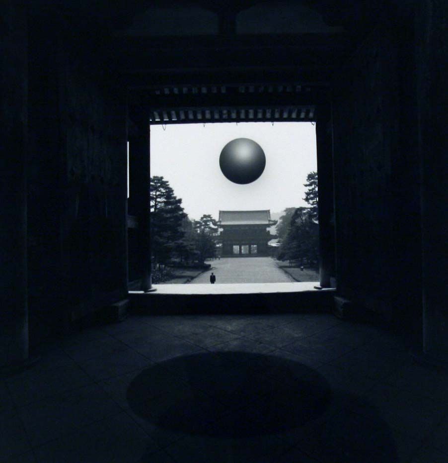 A person walks alone on a path between towering trees, with a large, mysterious sphere hovering in the overcast sky, casting an enigmatic shadow over a traditional building in the distance, creating a surreal and contemplative atmosphere that invites introspection and curiosity about the nature of reality and perception.