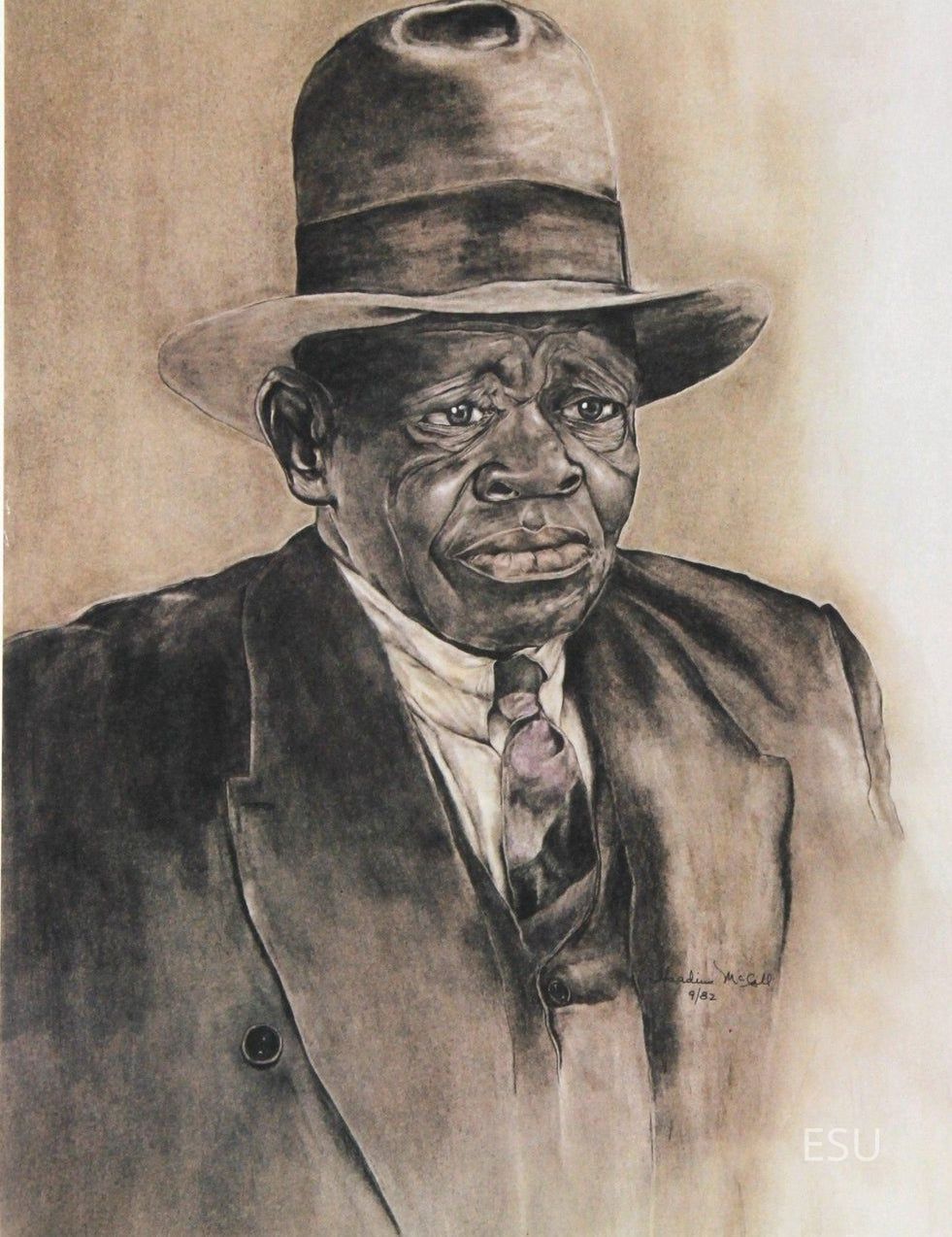 "Meet Big Daddy without his Cigar" by Theadius McCall (1983): The artwork depicts an elderly man with deep-set eyes and a pensive expression, wearing a classic, wide-brimmed hat that shadows his face, lending an air of mystery to his somber demeanor; he is dressed in a formal suit with a high-collared shirt and intricately knotted tie, suggesting a bygone era.