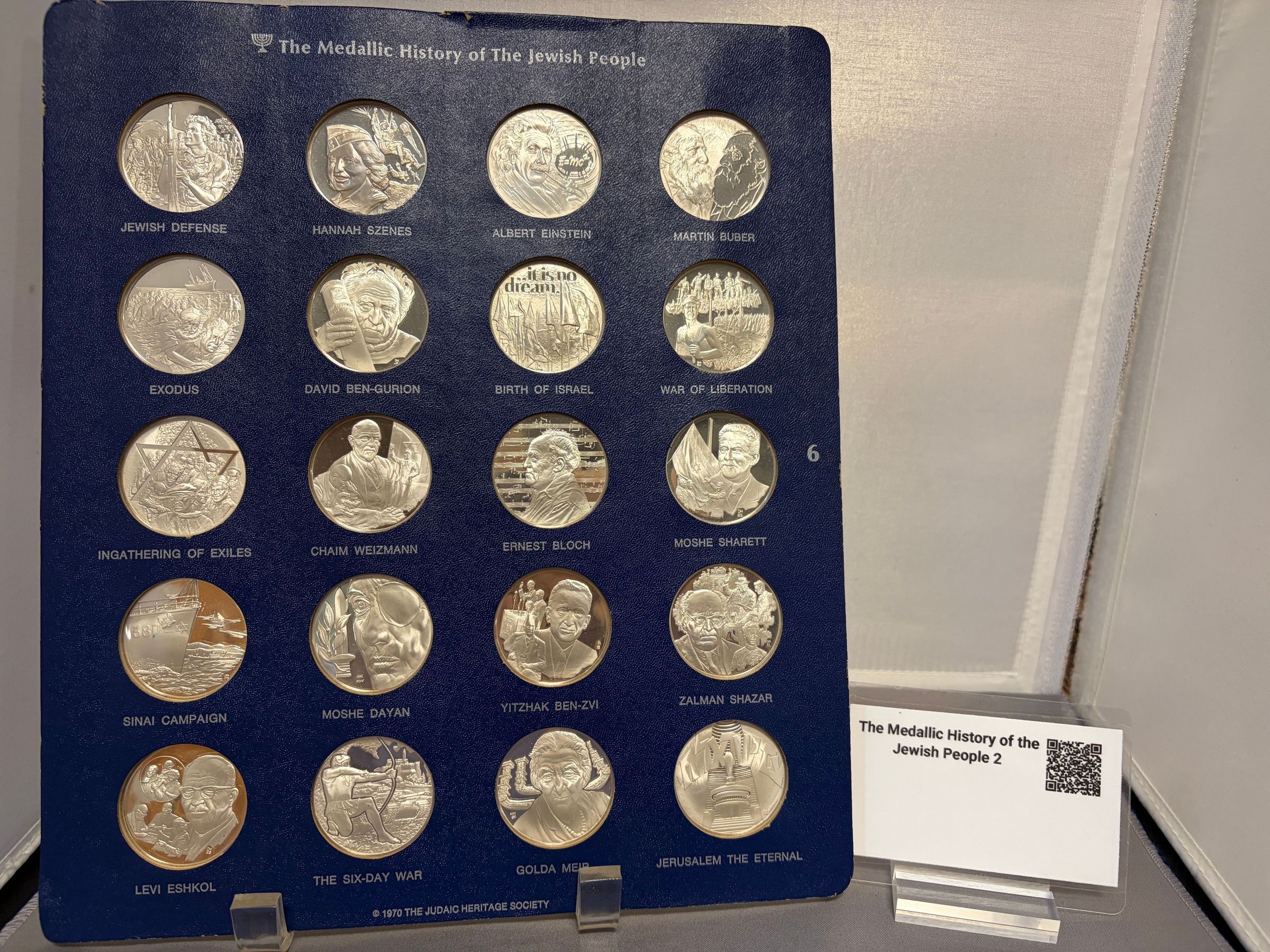 The Medallic history of the Jewish People (6): The Medallic history of the Jewish People (6)
The image displays an arrangement titled "The Medallic History of the Jewish People," featuring a collection of sixteen detailed medallions, each representing significant figures, events, and themes in Jewish history. Each medallion bears an inscription with names or iconic phrases such as "Jewish Defense," "Hannah Szenes," "Albert Einstein," and "Exodus," showcasing both influential individuals and pivotal moments.Q