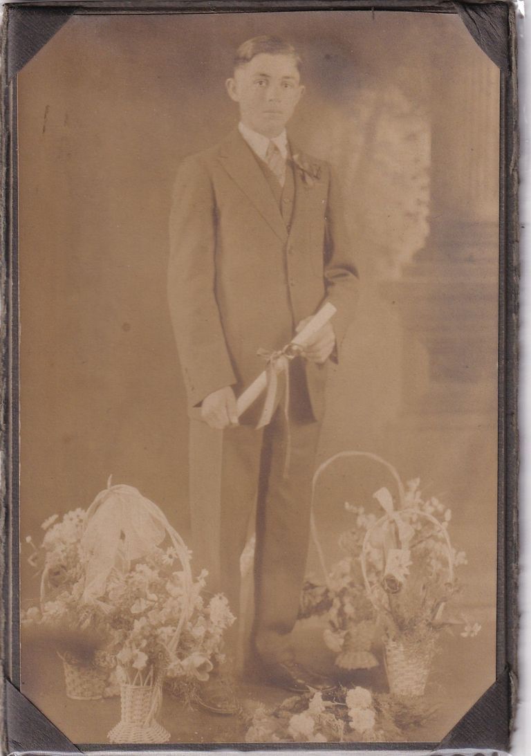 Formal Portrait of Young Man Holding Diploma with Floral Studio Props