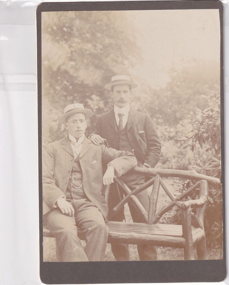 Two Gentlemen in Straw Boater Hats at Rustic Bench