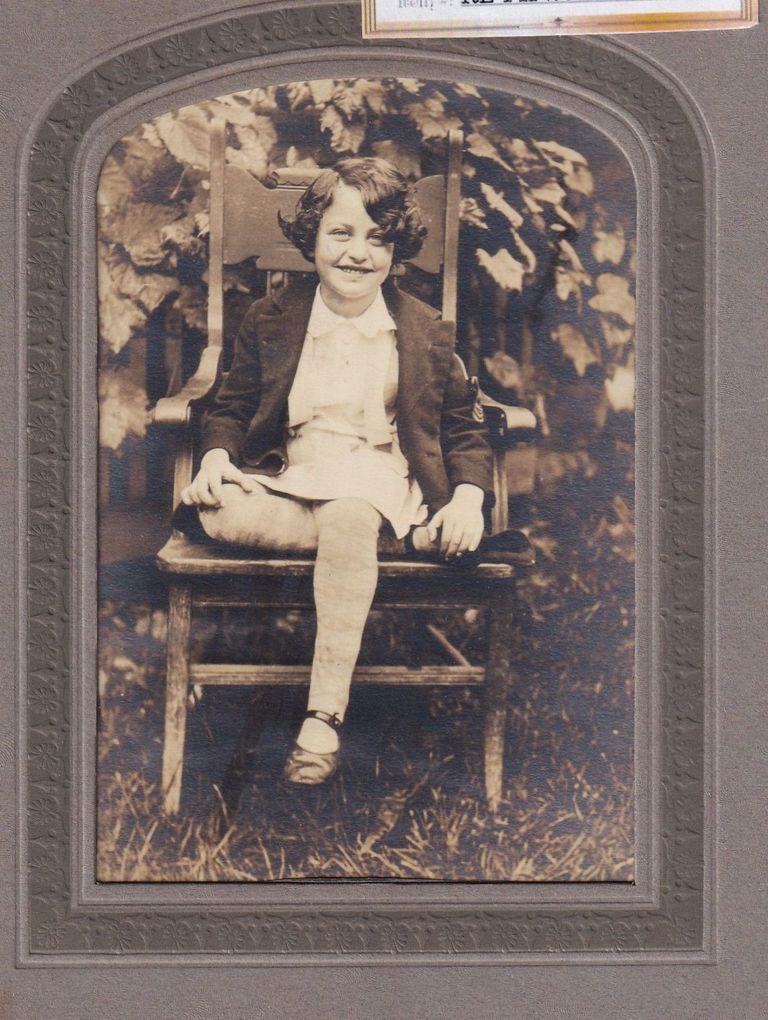 Portrait of Young Girl Seated Outdoors in Wooden Chair