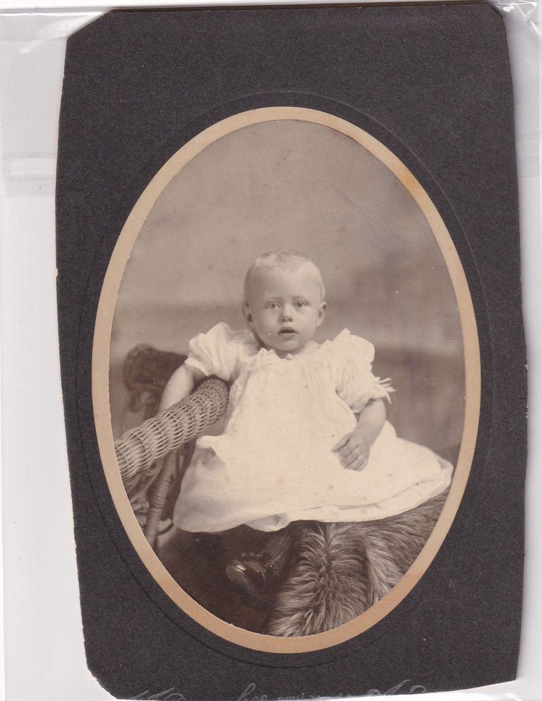Infant Seated on Wicker Chair — Oval Studio Portrait