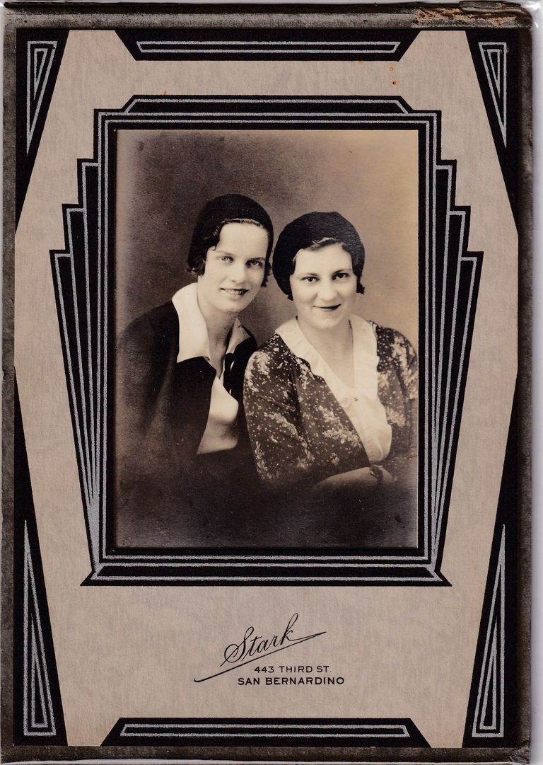 Studio portrait of two young women posed together, presented in a bold Art Deco mount.