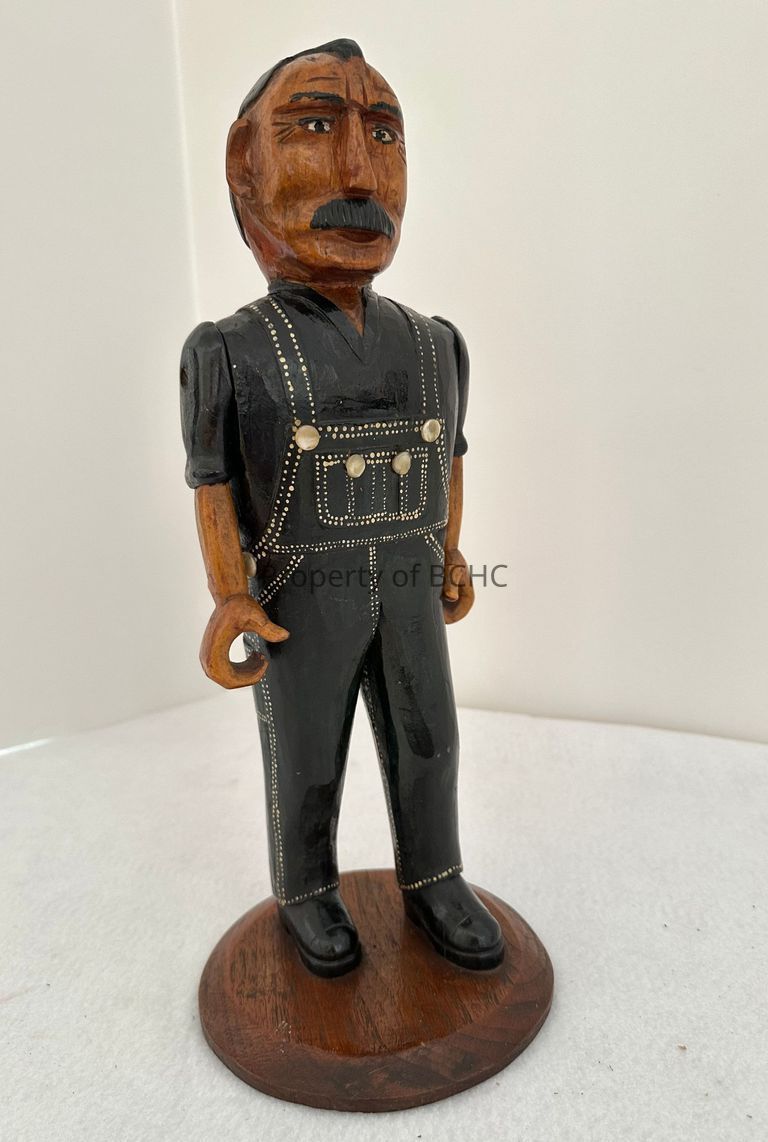Wood and painted carving of a man in blue overalls by folk artist and sculptor, Adelard Coté.