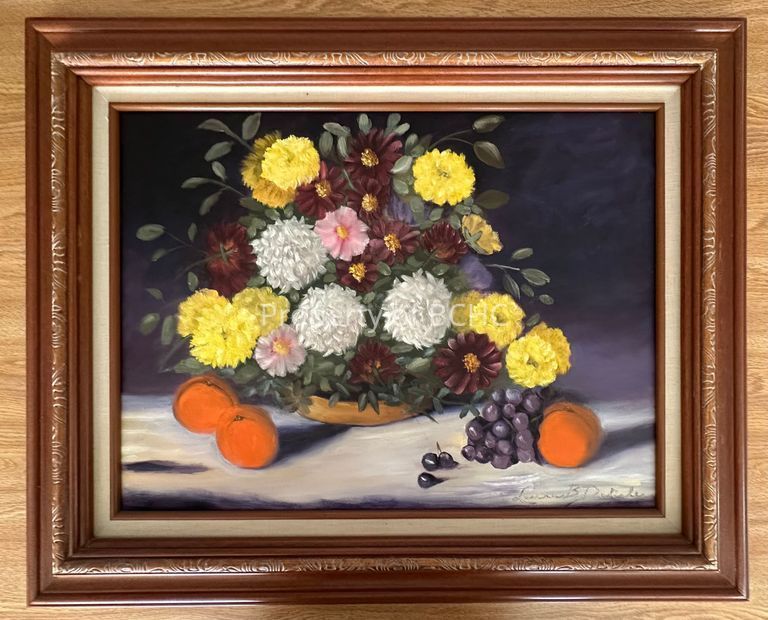Oil painting depicting yellow, white and pink flowers on a flat surface and in an. arrangement. There are also grapes and oranges. It is signed on the lower right hand corner, " Laura B. Deslisle."