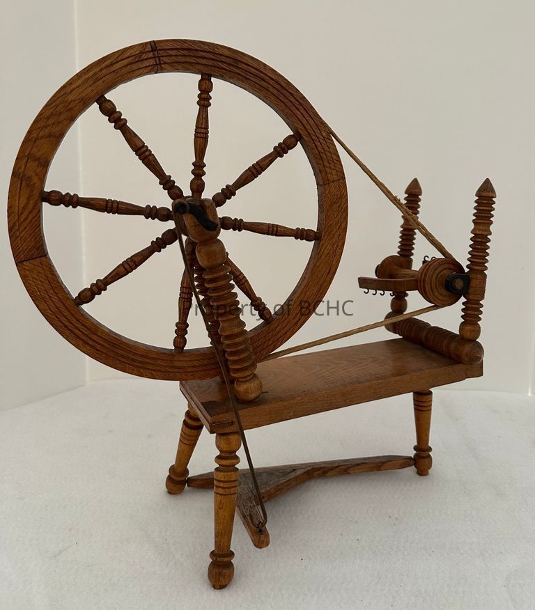 Wooden  carved spinning wheel with movable wheel and pedal.