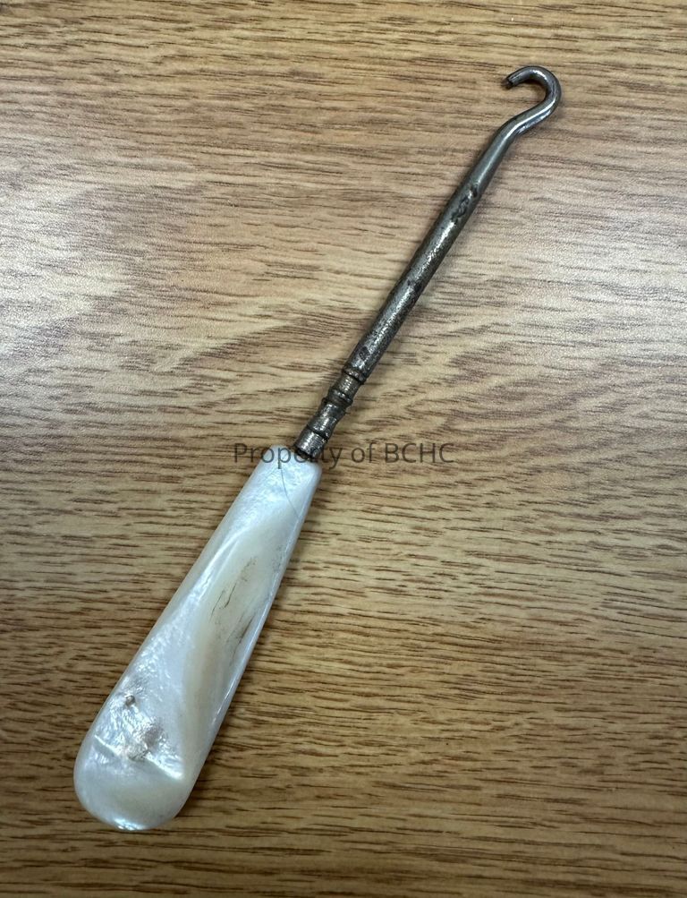Ivory handled button hook used to pull buttons through button holes.
