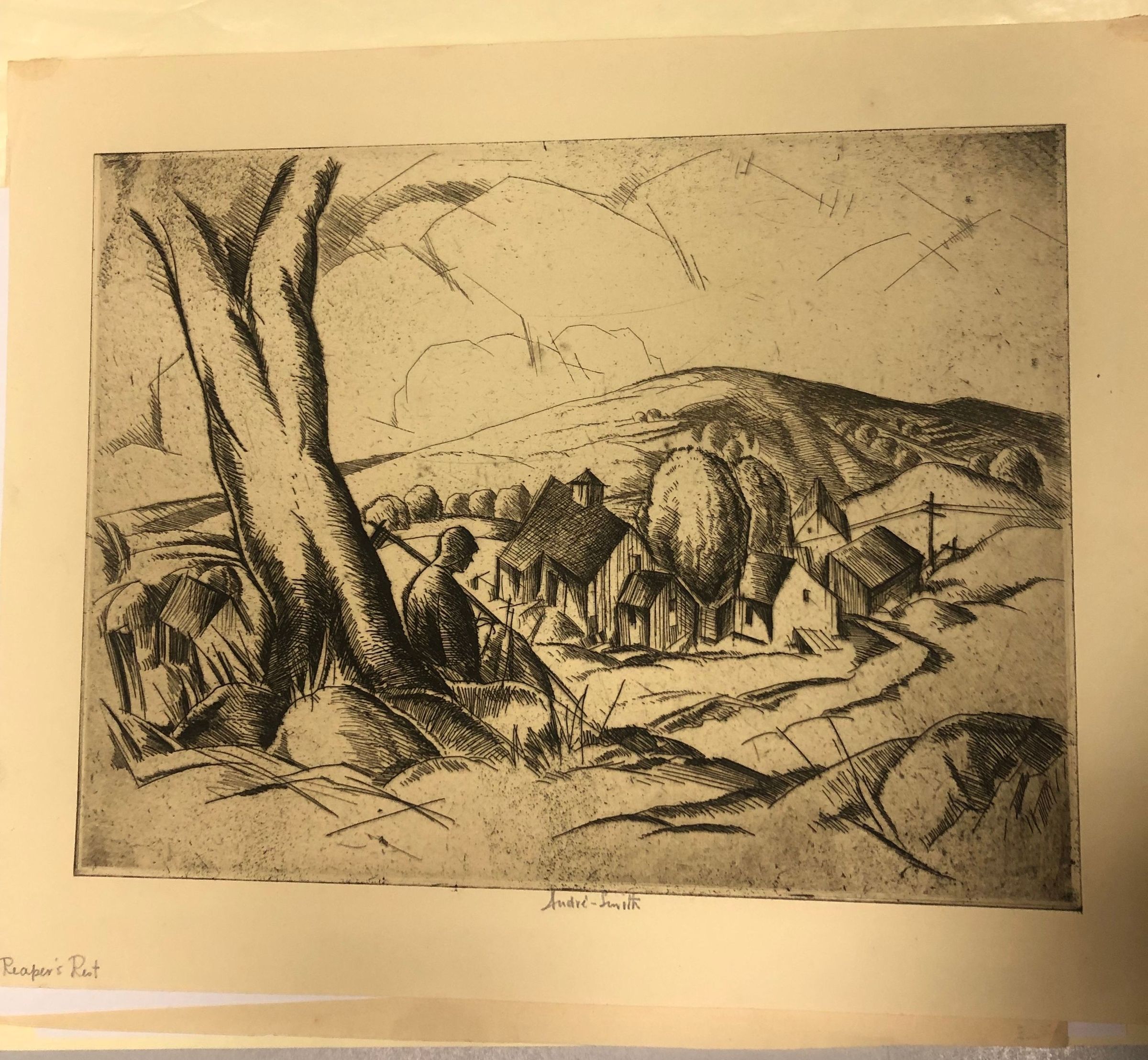 In "Reaper's Rest," a hooded figure with a scythe rests beneath a tree above a quiet farm valley.: A hooded, cloaked figure sits in the shade of a broad tree, the long handle of a scythe beside him, and looks down over a small cluster of farm buildings in the valley below. At first glance he could be a field hand pausing from the harvest, but his hooded cape and scythe also recall the traditional figure of the Grim Reaper, watching quietly over the village. Smith never resolves which the figure is, and that deliberate ambiguity hints at an interest in Surrealism, where ordinary scenes take on an uncanny, dreamlike edge. A road winds past the barns, and utility poles and rolling hills stretch toward the horizon. Smith simplifies the trees and hillsides into rounded, sculptural shapes and breaks the sky into crisp, angular lines, creating a landscape that is at once pastoral and quietly unsettling.