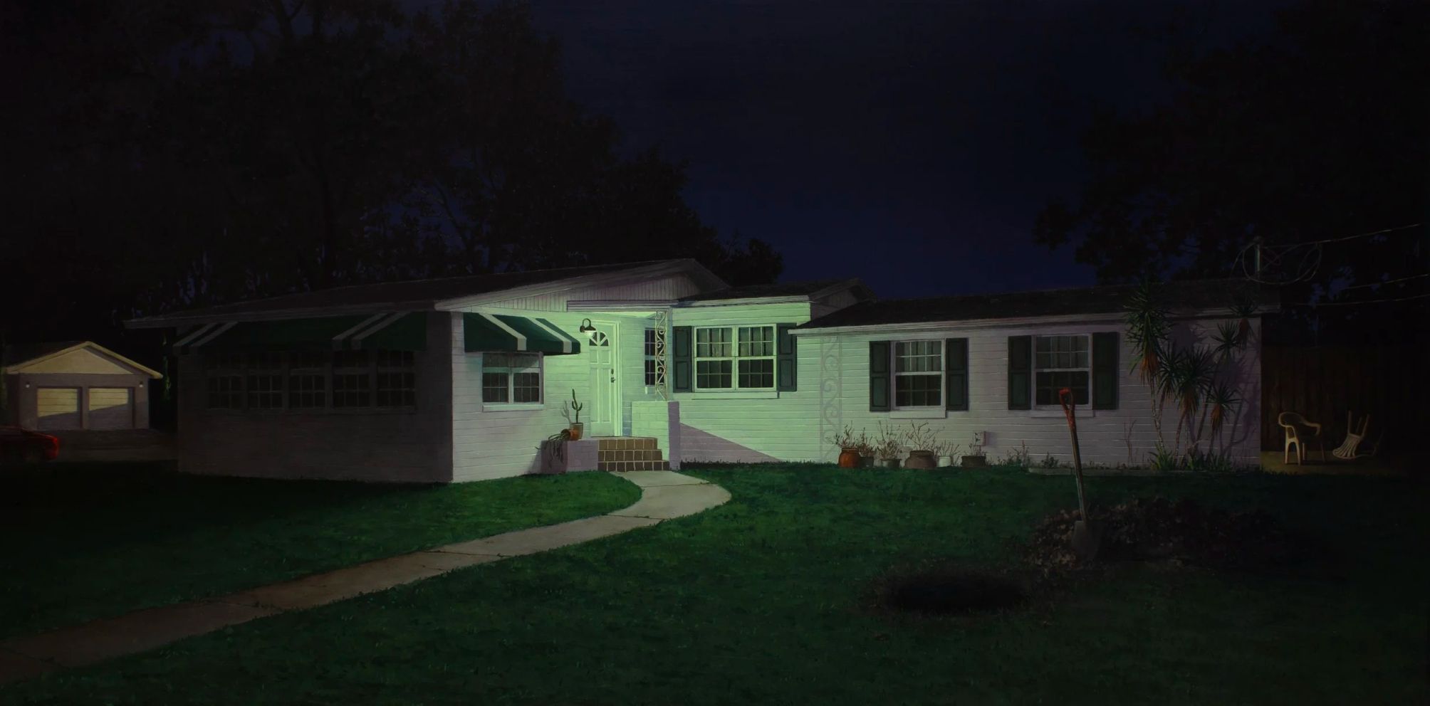 In the image, a modest suburban house stands illuminated by a warm porch light against the backdrop of a deep, dark night sky, casting a serene and inviting glow on its white facade and green shutters. The house features a covered front entrance with steps leading to a white door, flanked by a pair of potted plants adding a touch of life to the scene. A neatly mown lawn extends from the front door, accompanied by a curved path that guides the eye towards the house.