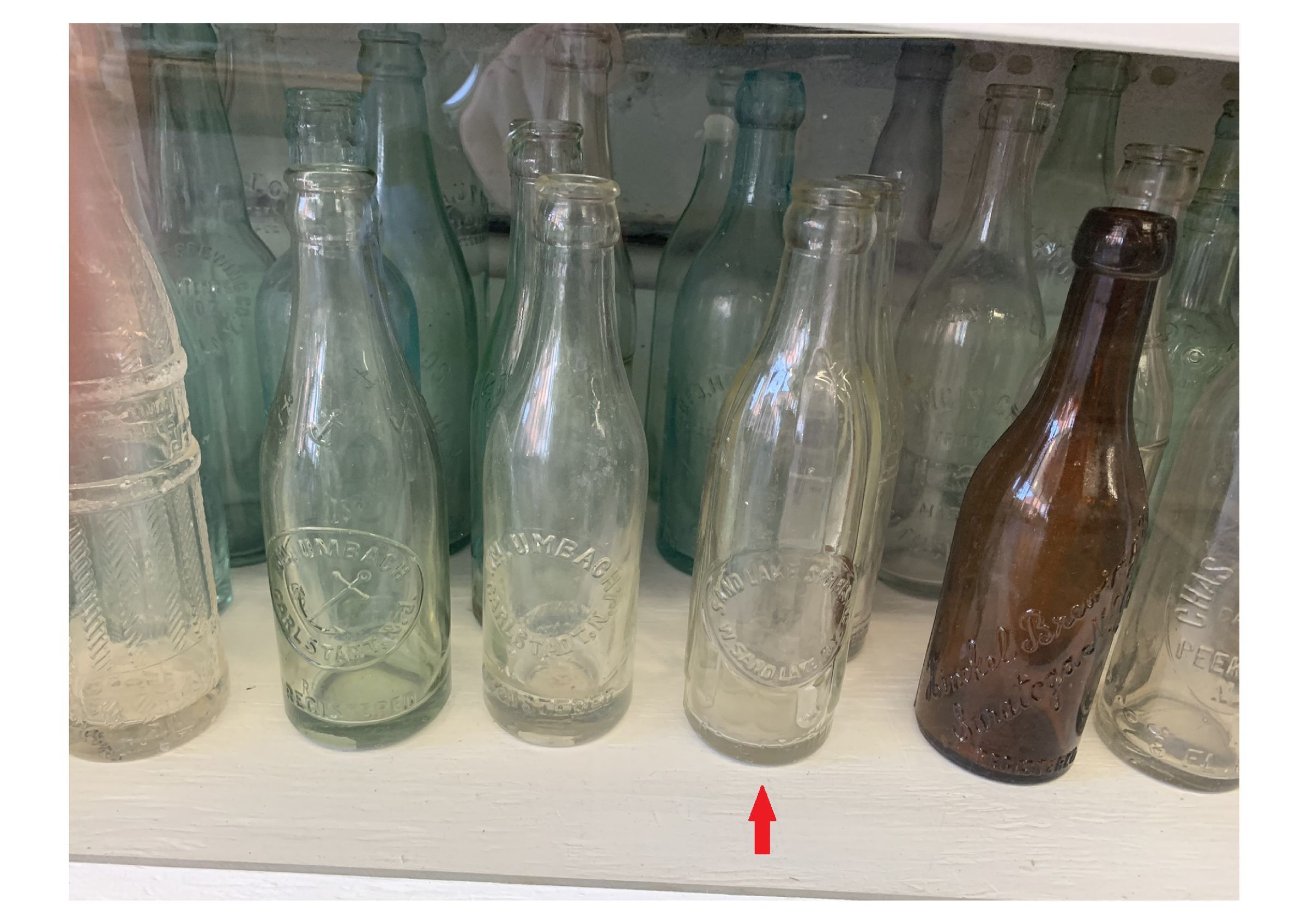Eight-page PDF of photos taken at the National Bottle Museum: The red arrow in the photos highlights the location of the Sand Lake Springs bottle.