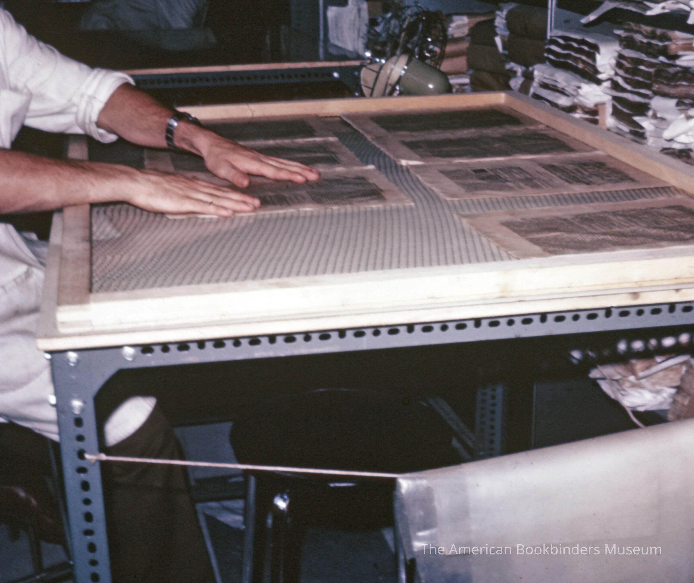          A scan of a slide showing someone laying pages on a table picture number 1
   