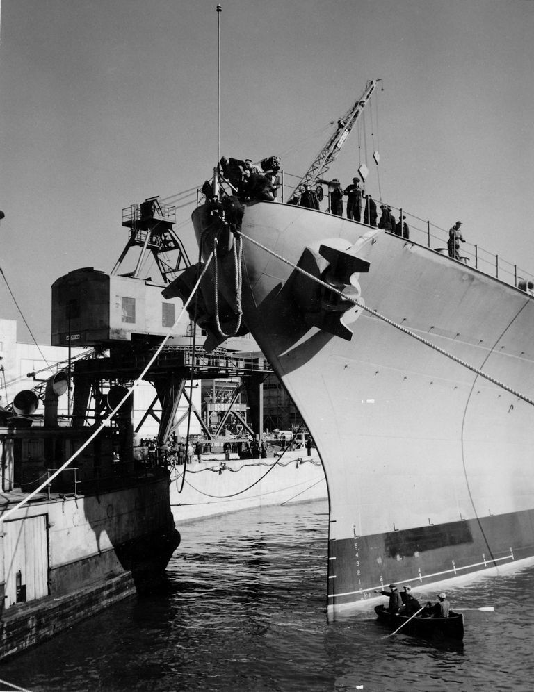          Workers continue to position IOWA over her keel blocks. Note size comparison of the boat and IOWA's bow. October 20, 1942 - 80-G-13562 picture number 1
   