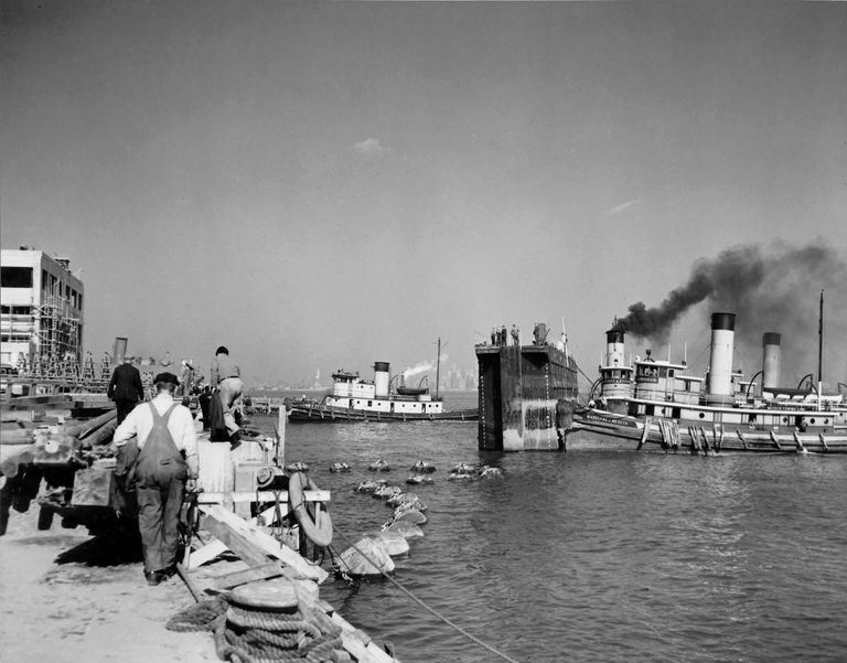          Tug boats begin moving the dry dock caisson into position to close the dock with Iowa inside. October 20, 1942 - 80-G-13559 picture number 1
   