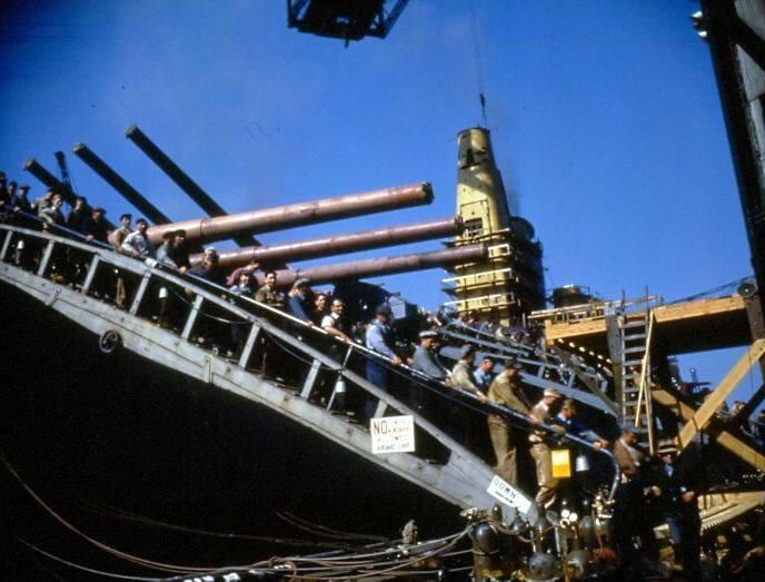          Shipyard workers departing IOWA from the forward gangway. Turrets 1 & 2's guns have been installed. Oct 1942 - 80-G-K-517 picture number 1
   