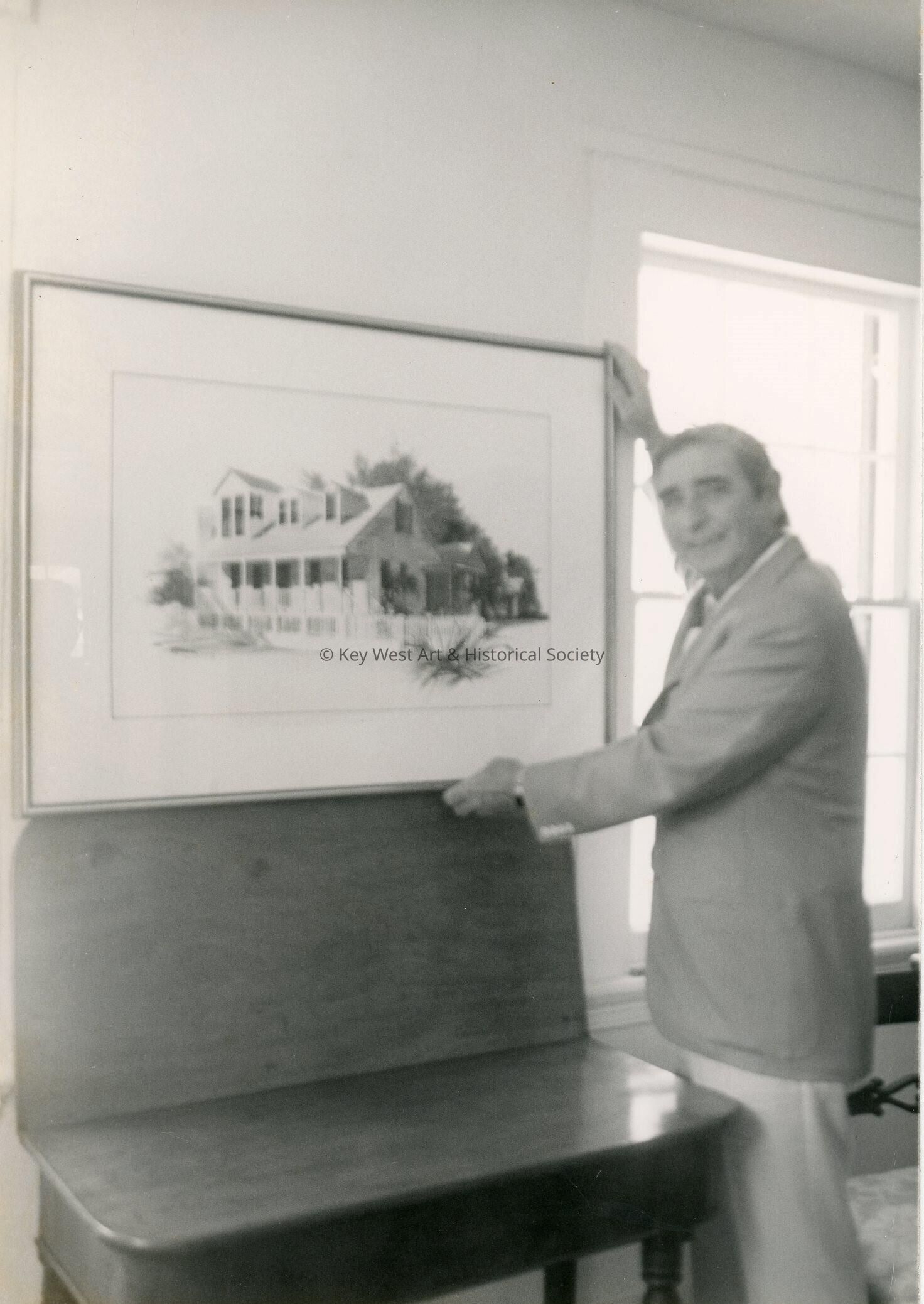 An unknown man holding a piece of art work
