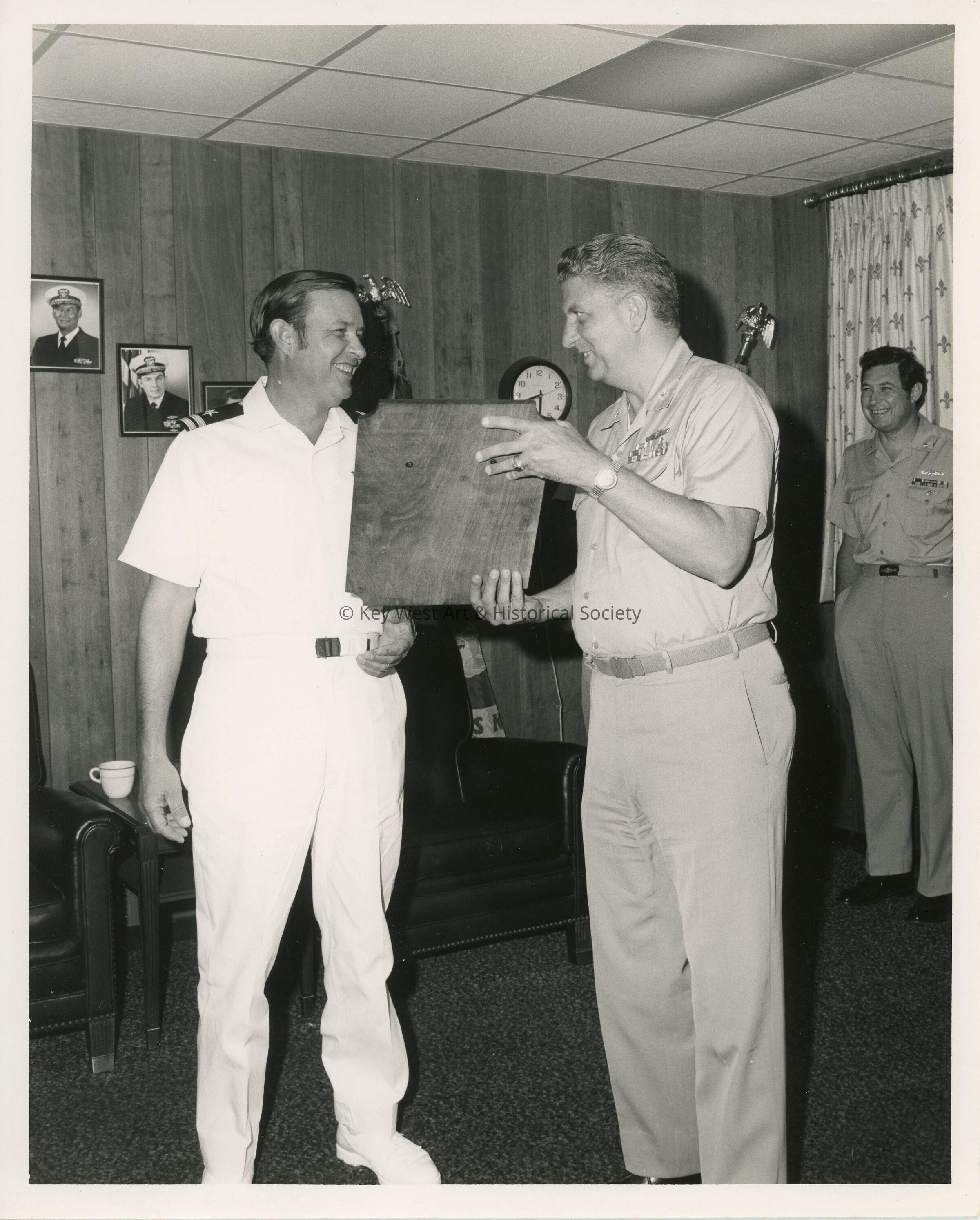 A man in uniform receiving a plaque at a ceremony