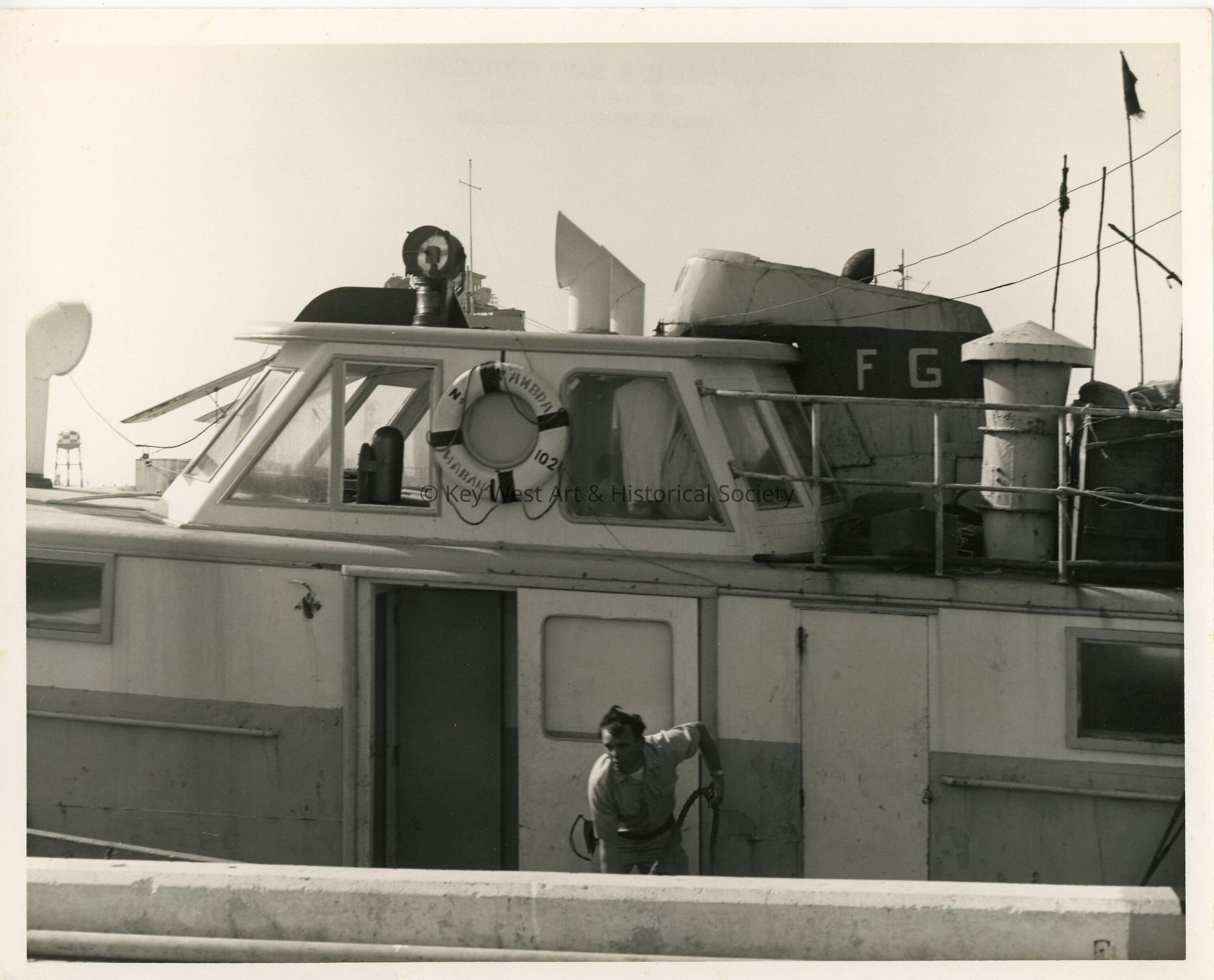 An unknown man in uniform cleaning a boat