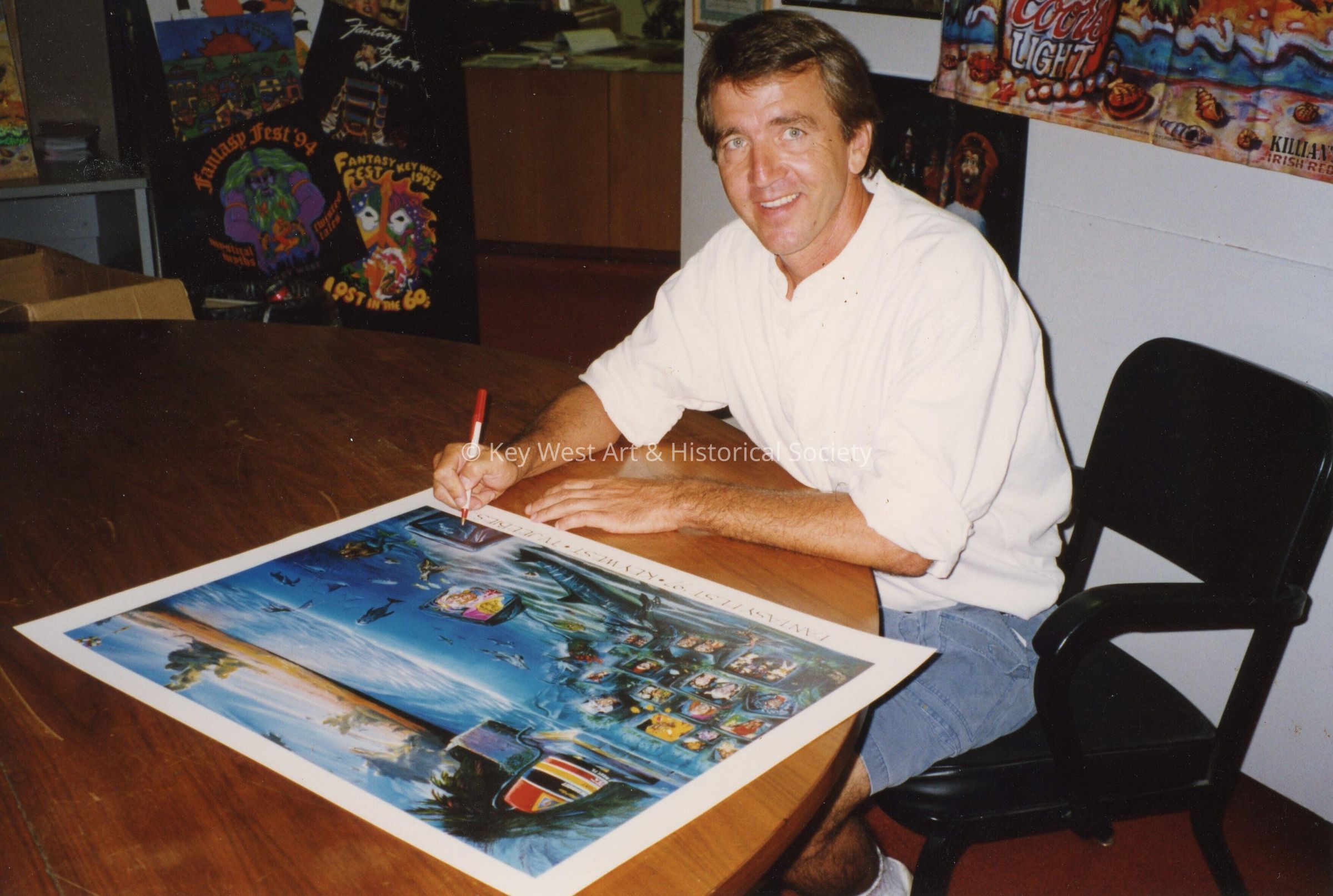 An unknown man writing or signing a poster.