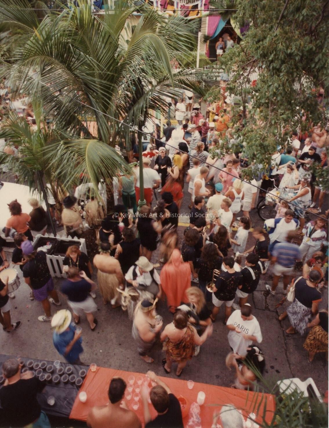 An Unknown group of people standing outside, some are dressed up in front o