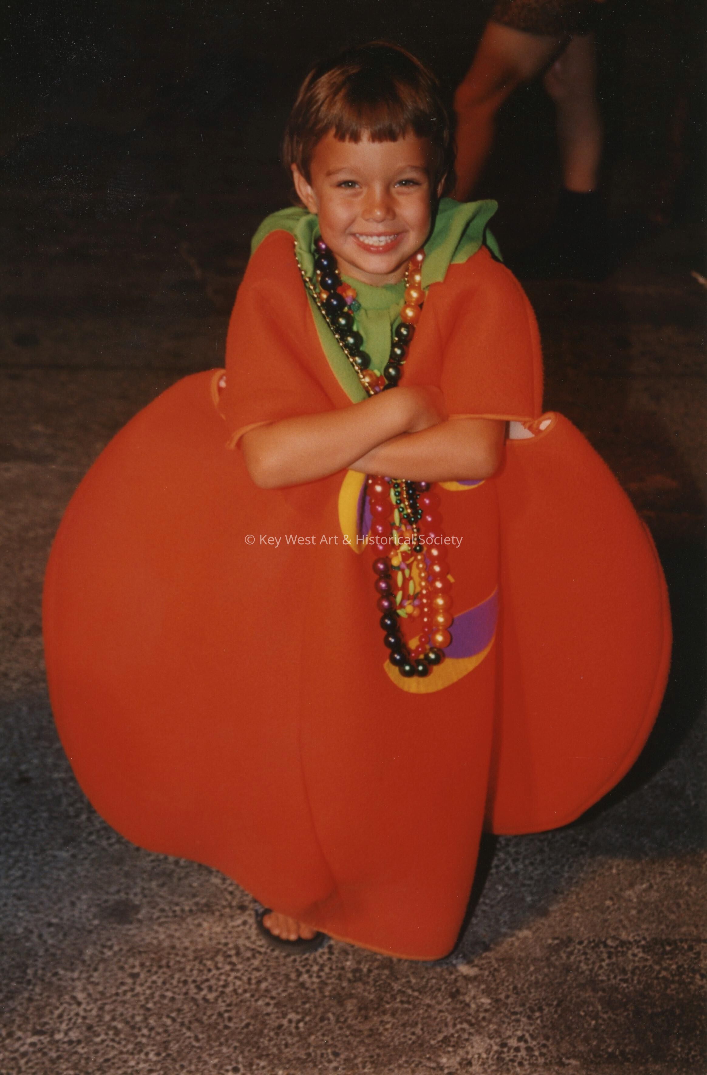 An unknown child dressed up as a pumpkin.