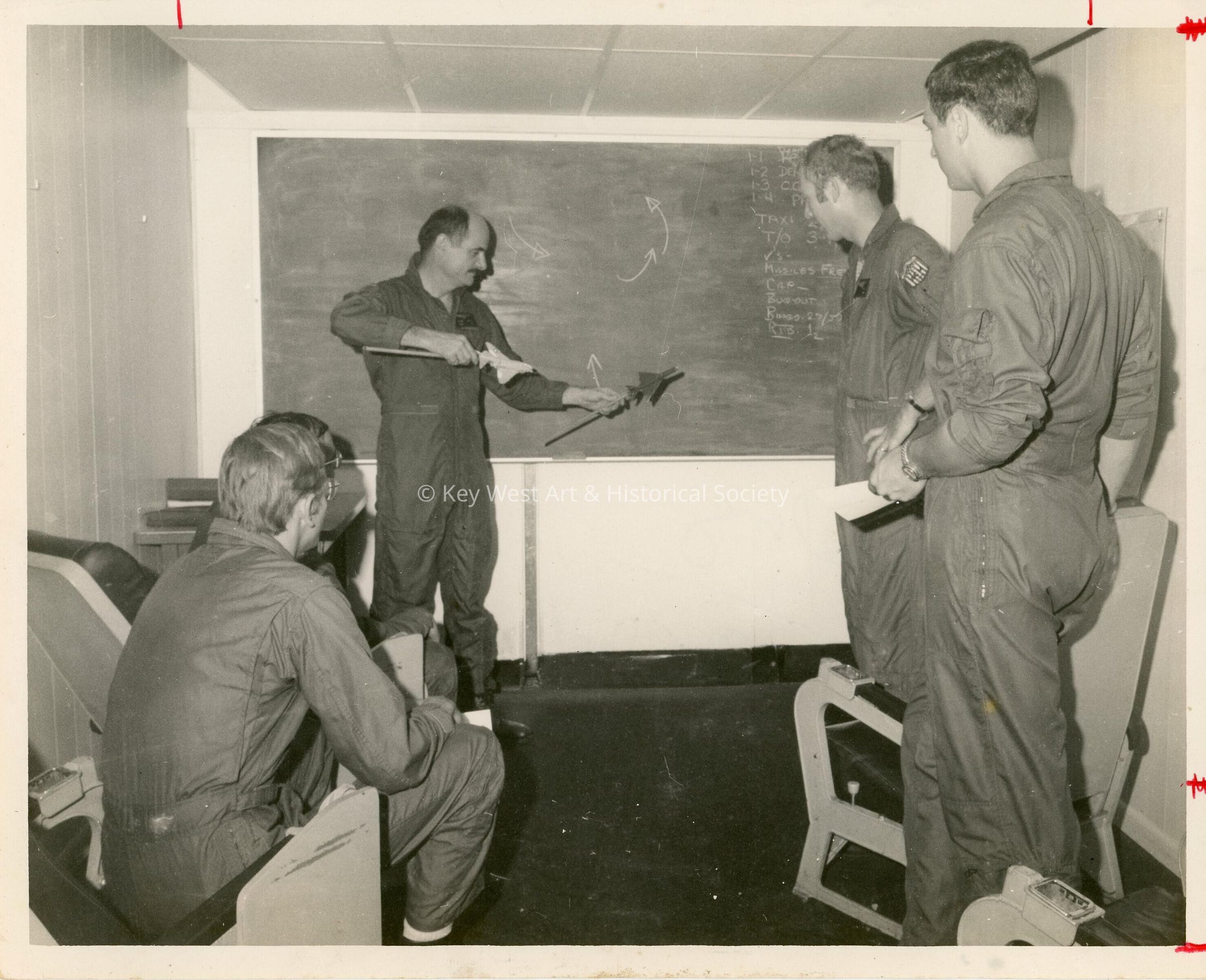 4 Unknown men in uniform talking in an office