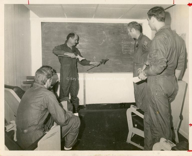 4 Unknown men in uniform talking in an office