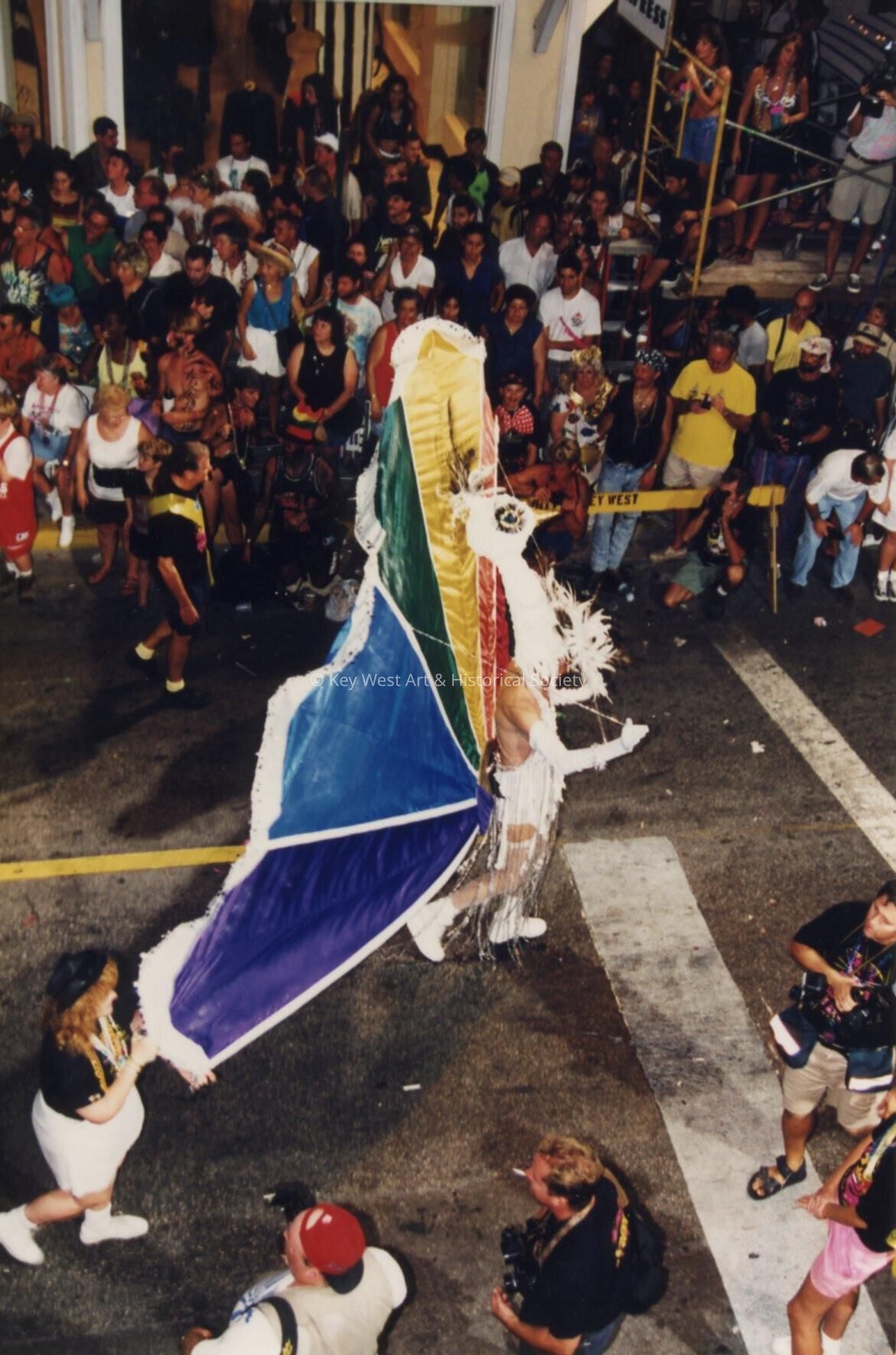 An unknown person dressed up and walking down the street for  the parade.