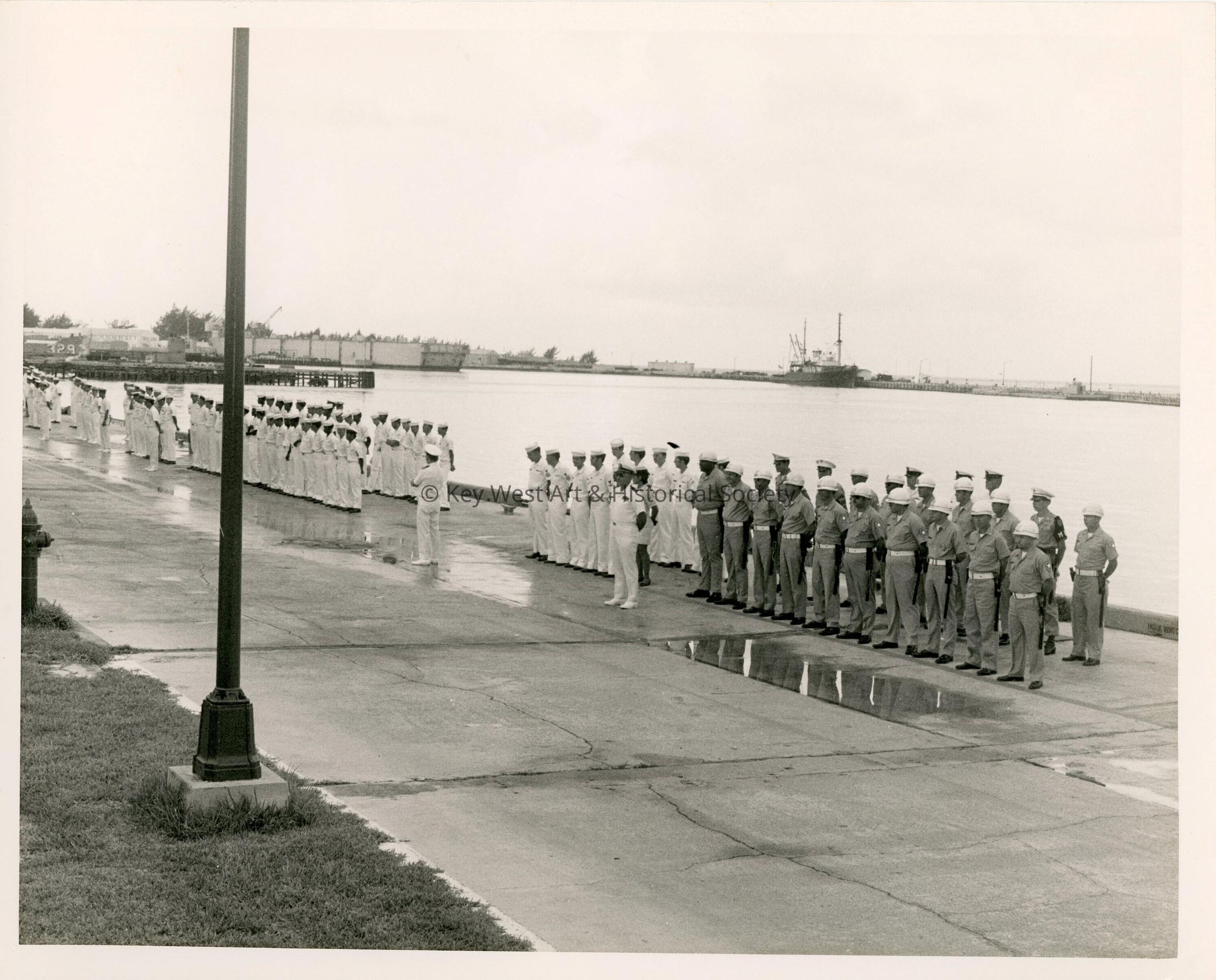 A group of men in uniform standing by the pier