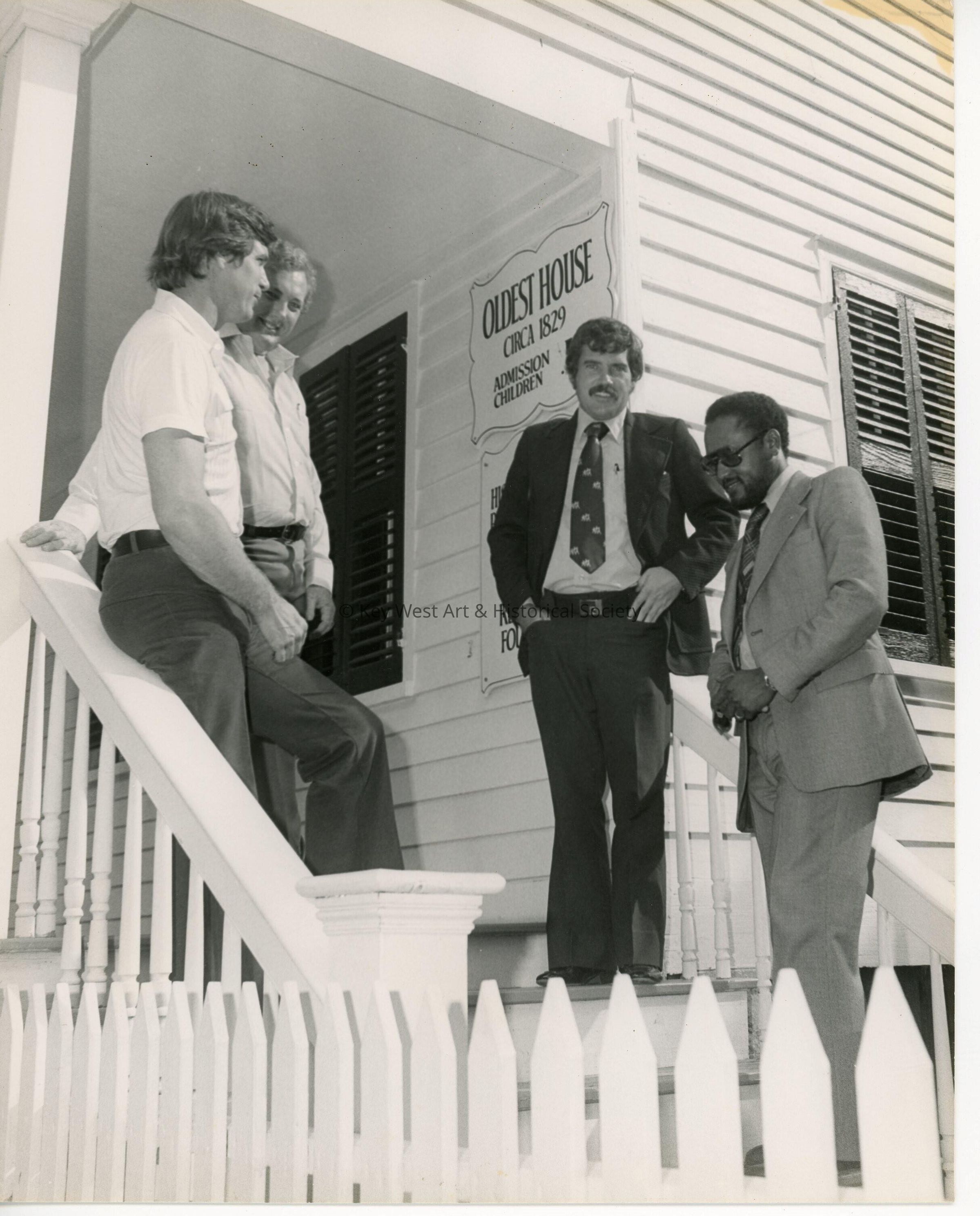 4 Unknown men standing outside of the oldest house