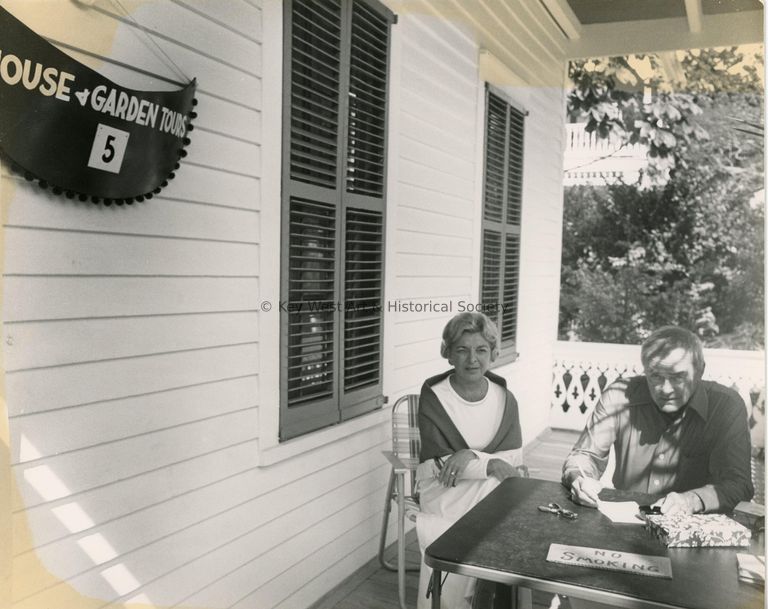 2 Unknown people sitting outside of a museum