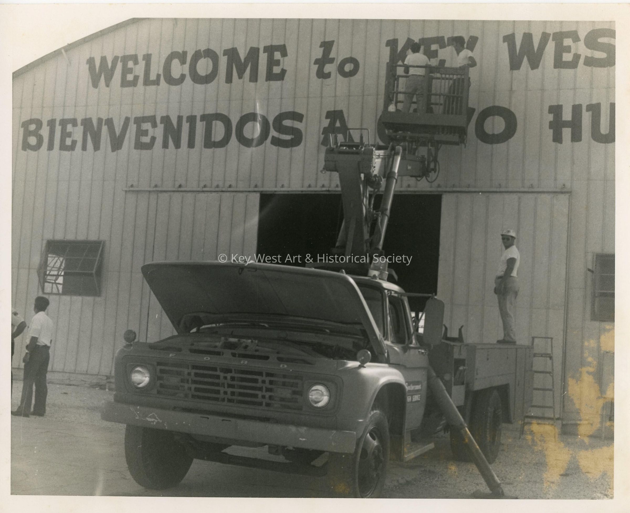 A truck putting up a sign on a building