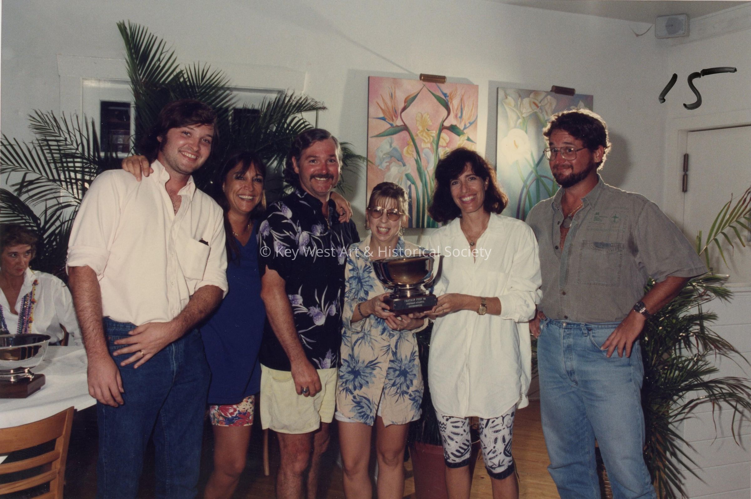 A group of unknown people accepting a trophy.