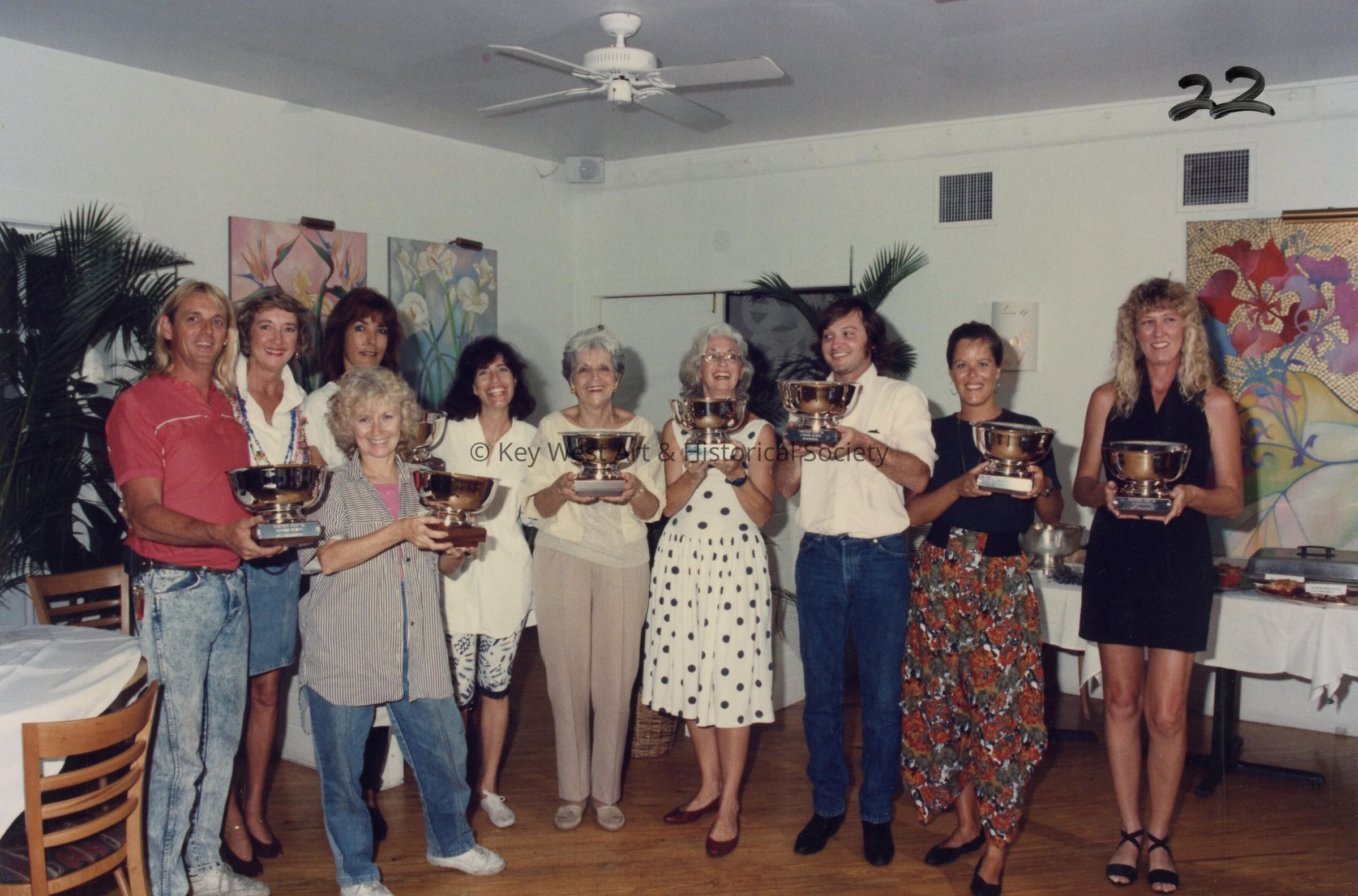 A group of unknown people accepting a trophy.