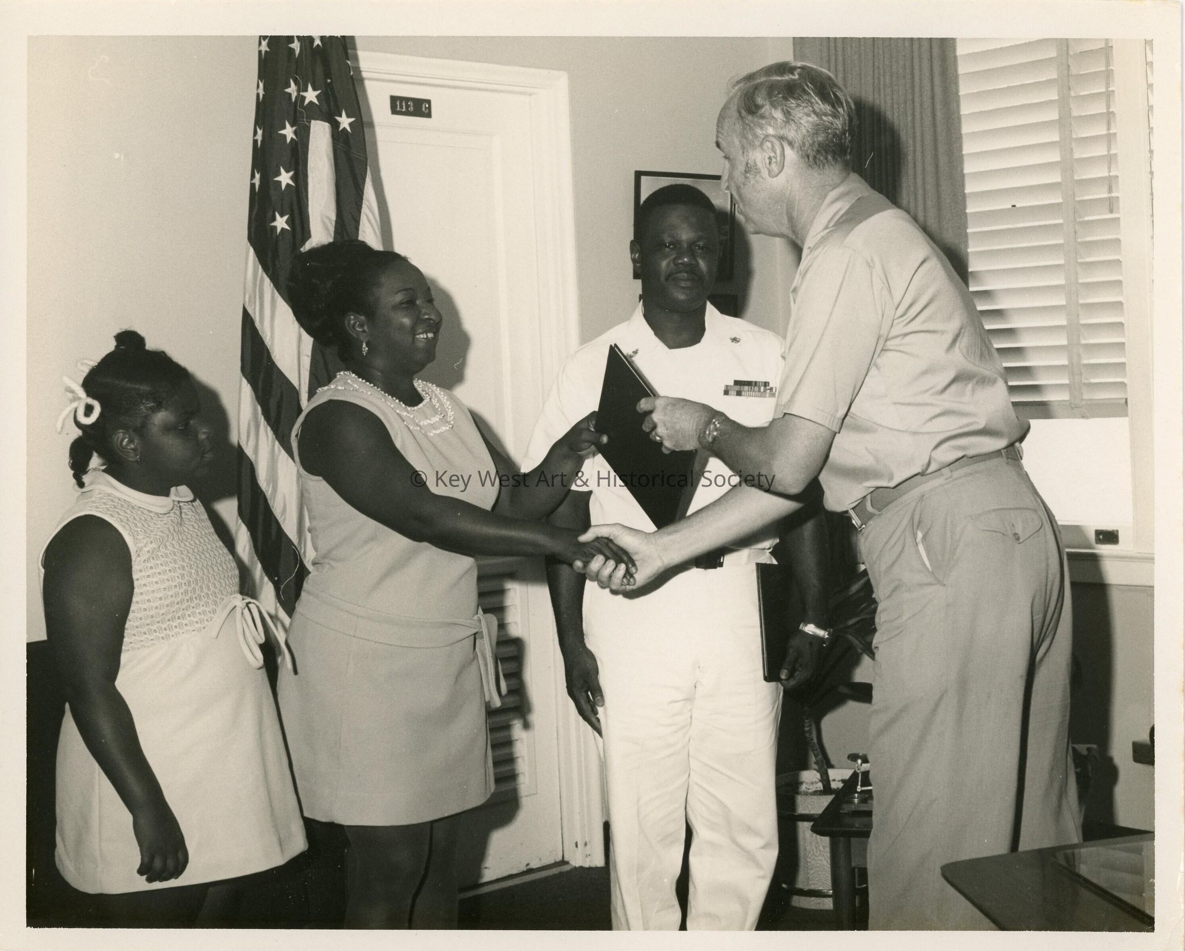 An unknown man presenting a family a plaque