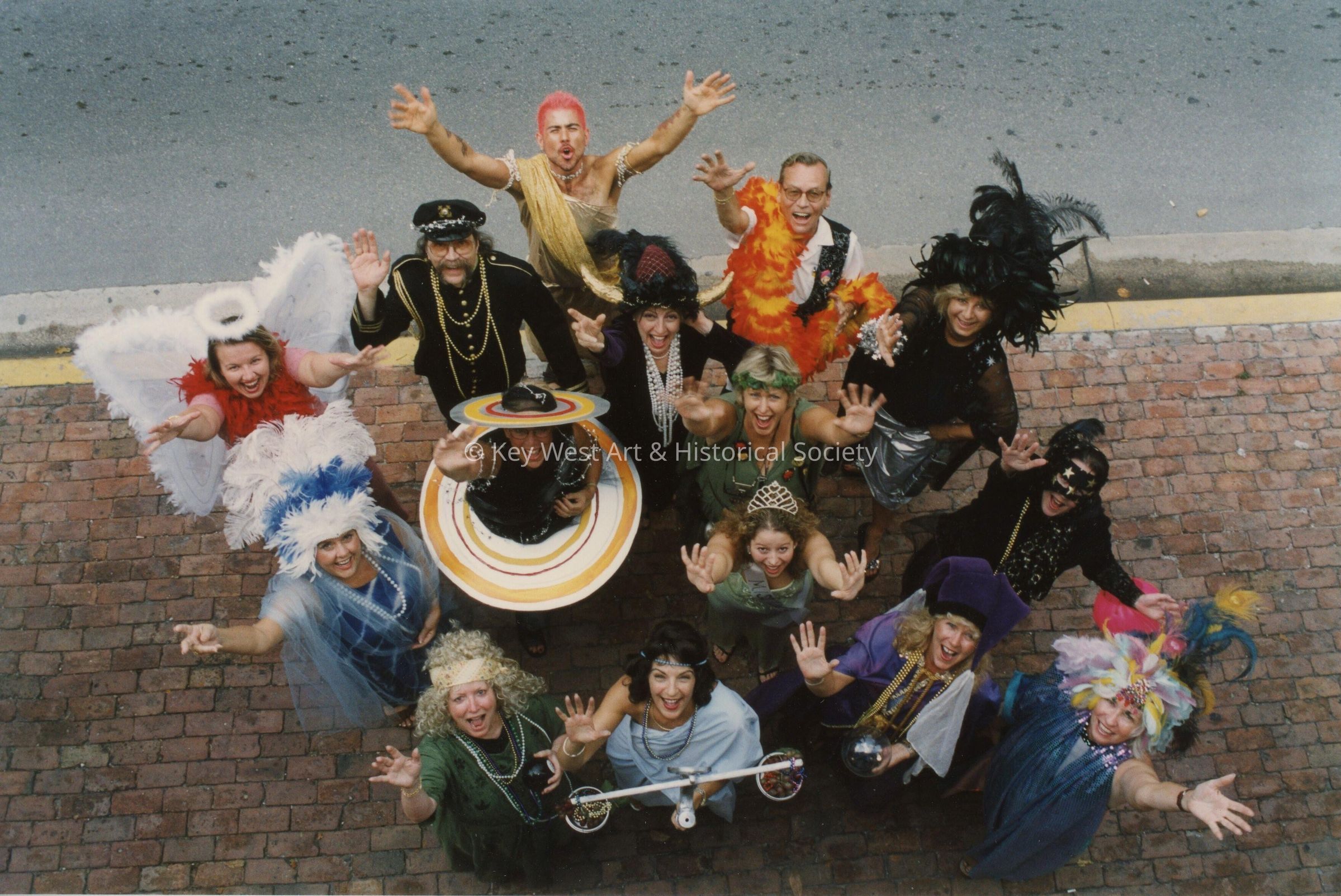 A group of unknown people dressed up looking up at the camera.