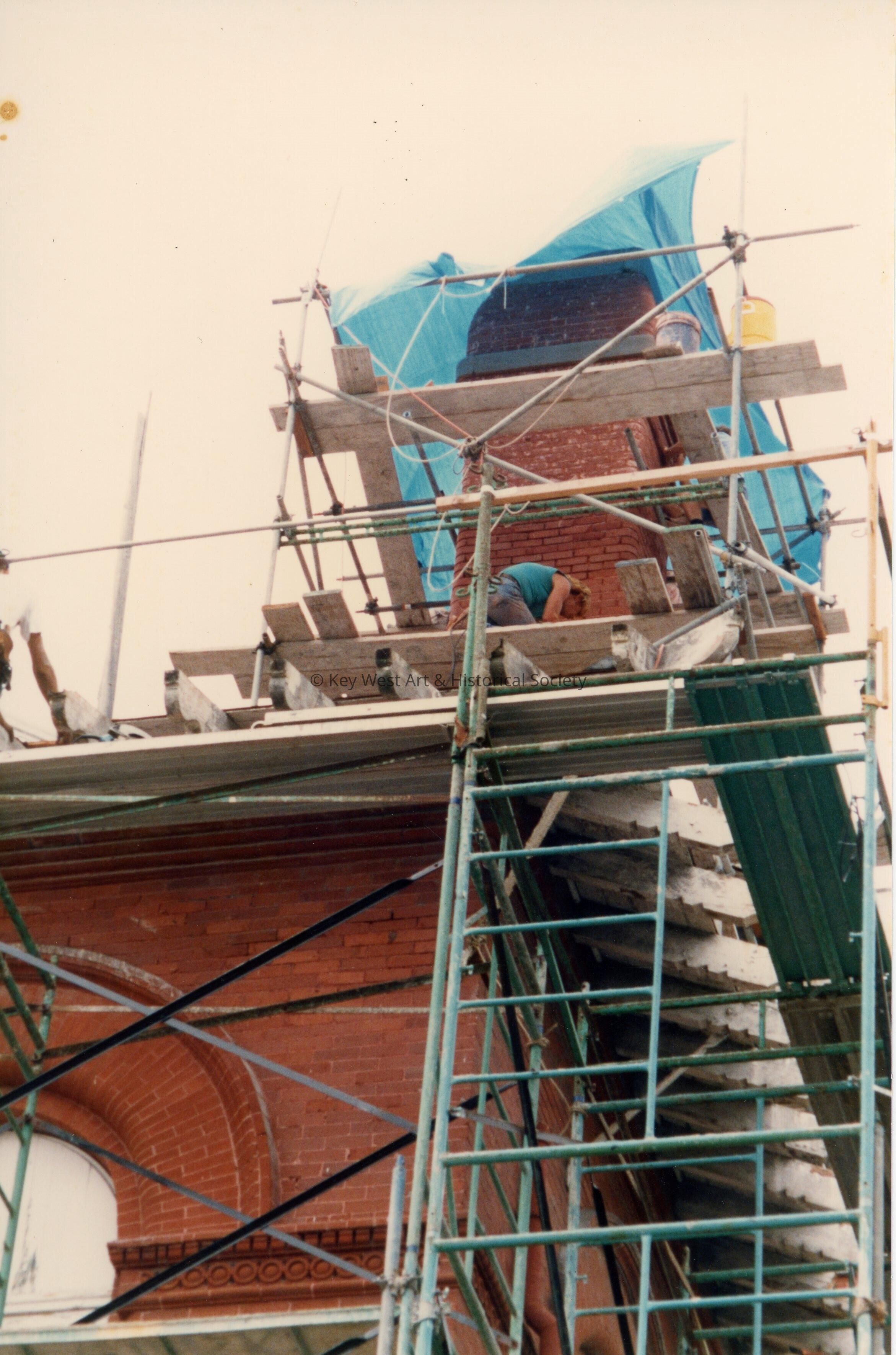 An unknown  man working on the roof.