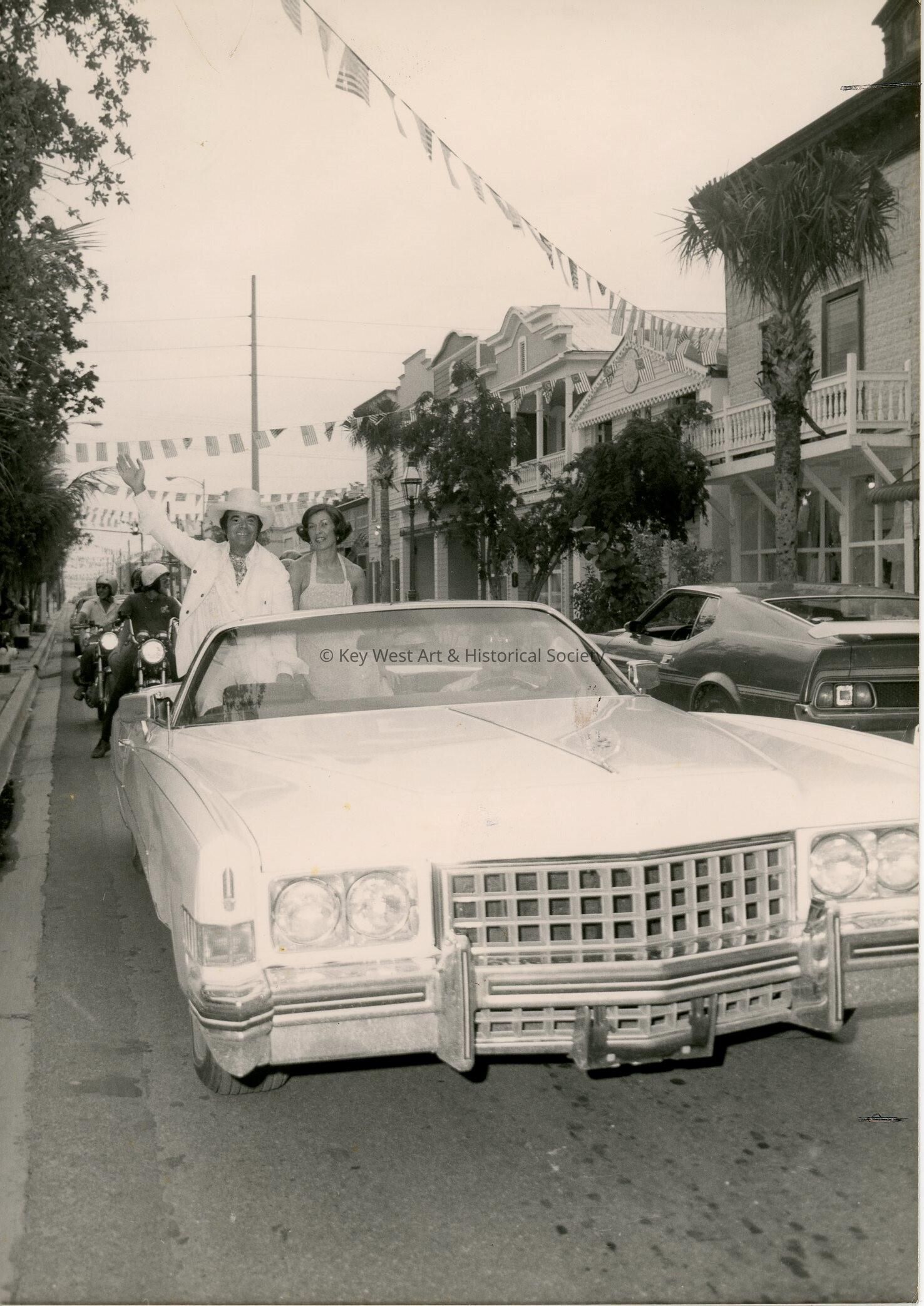 An unknown couple sitting on a car
