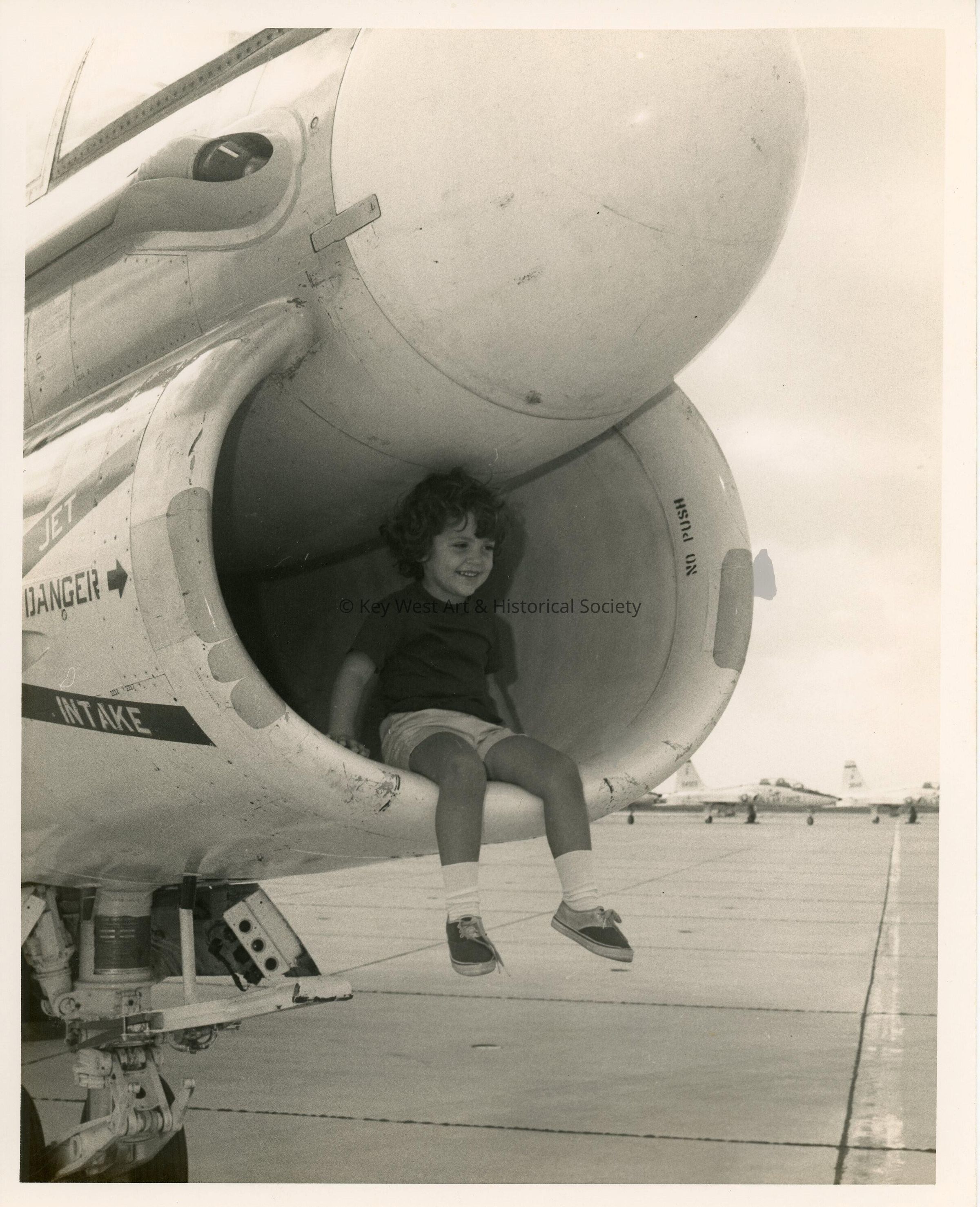 A U.S. navy jet with a child sitting inside