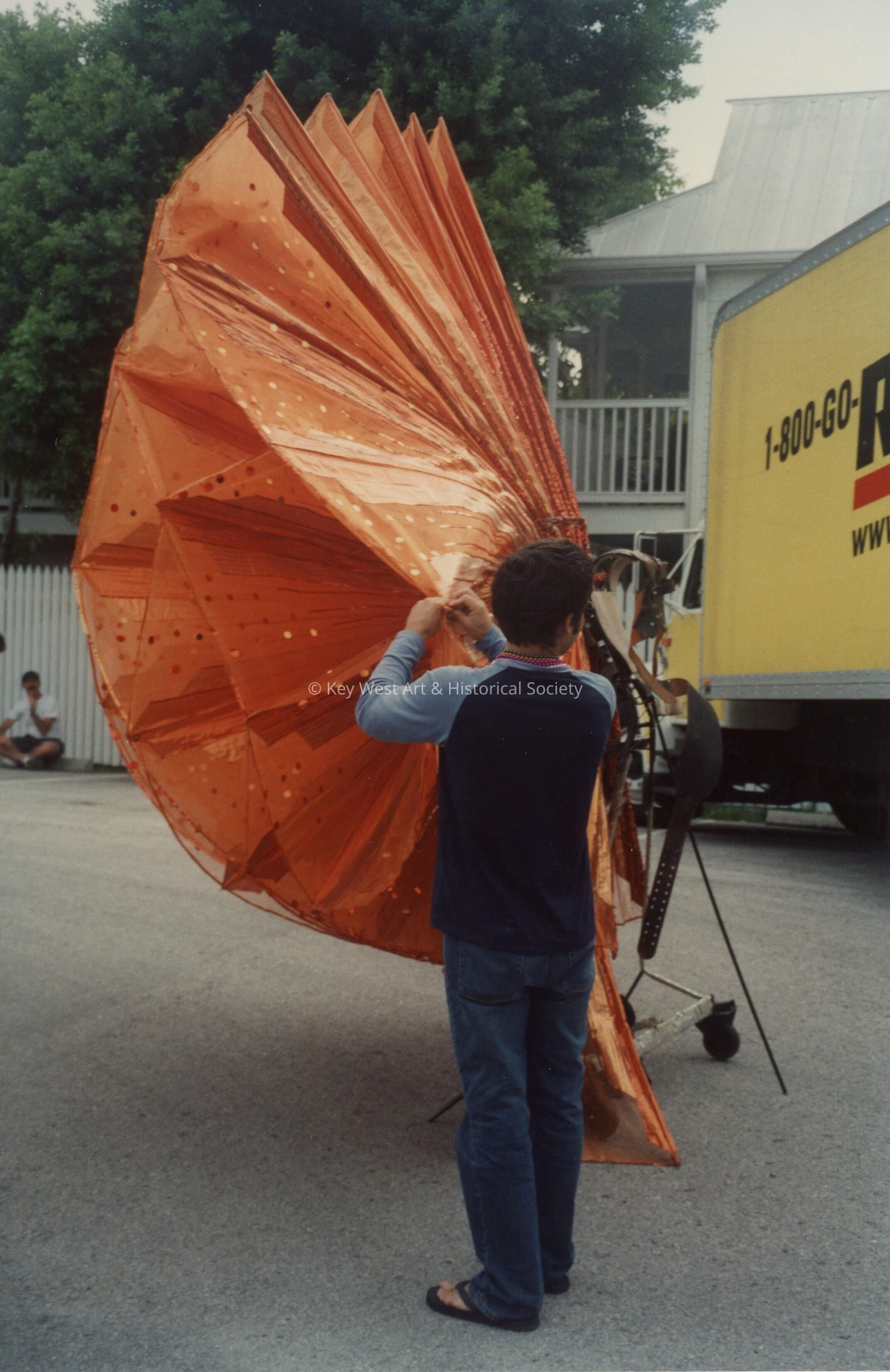 An unknown man preparing an object that will be in the parade.