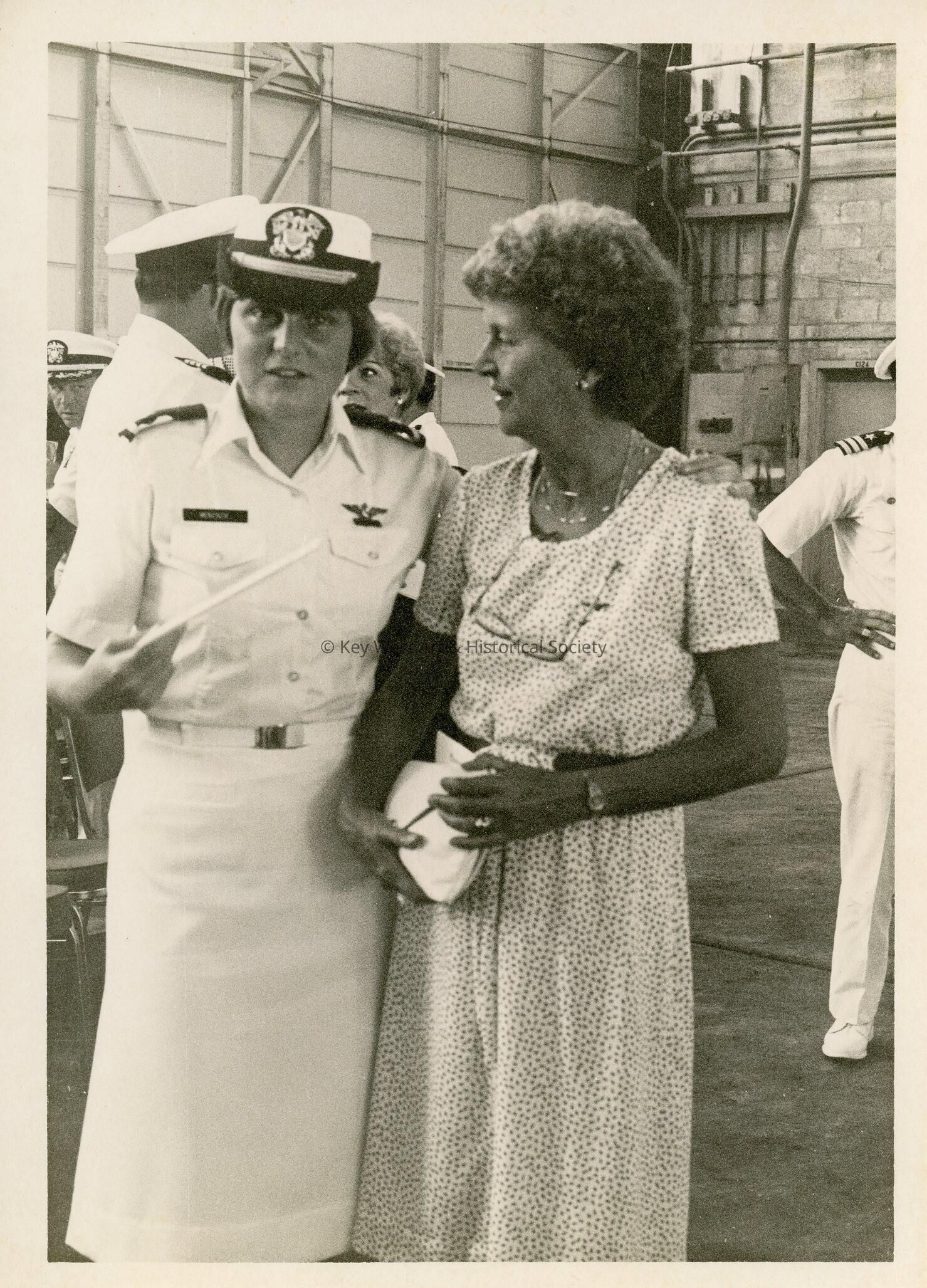 A lady in uniform standing with a woman