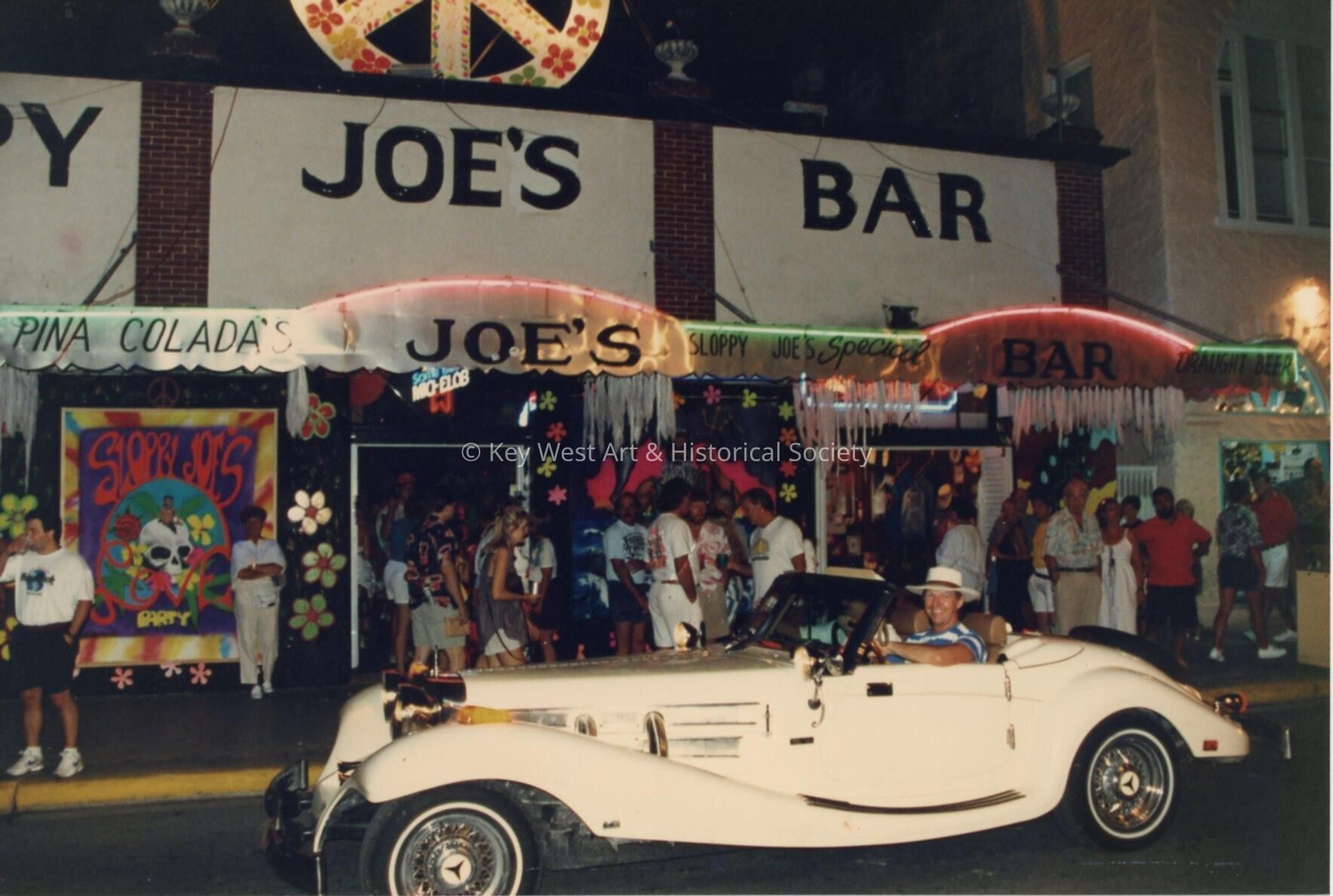 An old car in front of Sloppy Joe's Bar.
