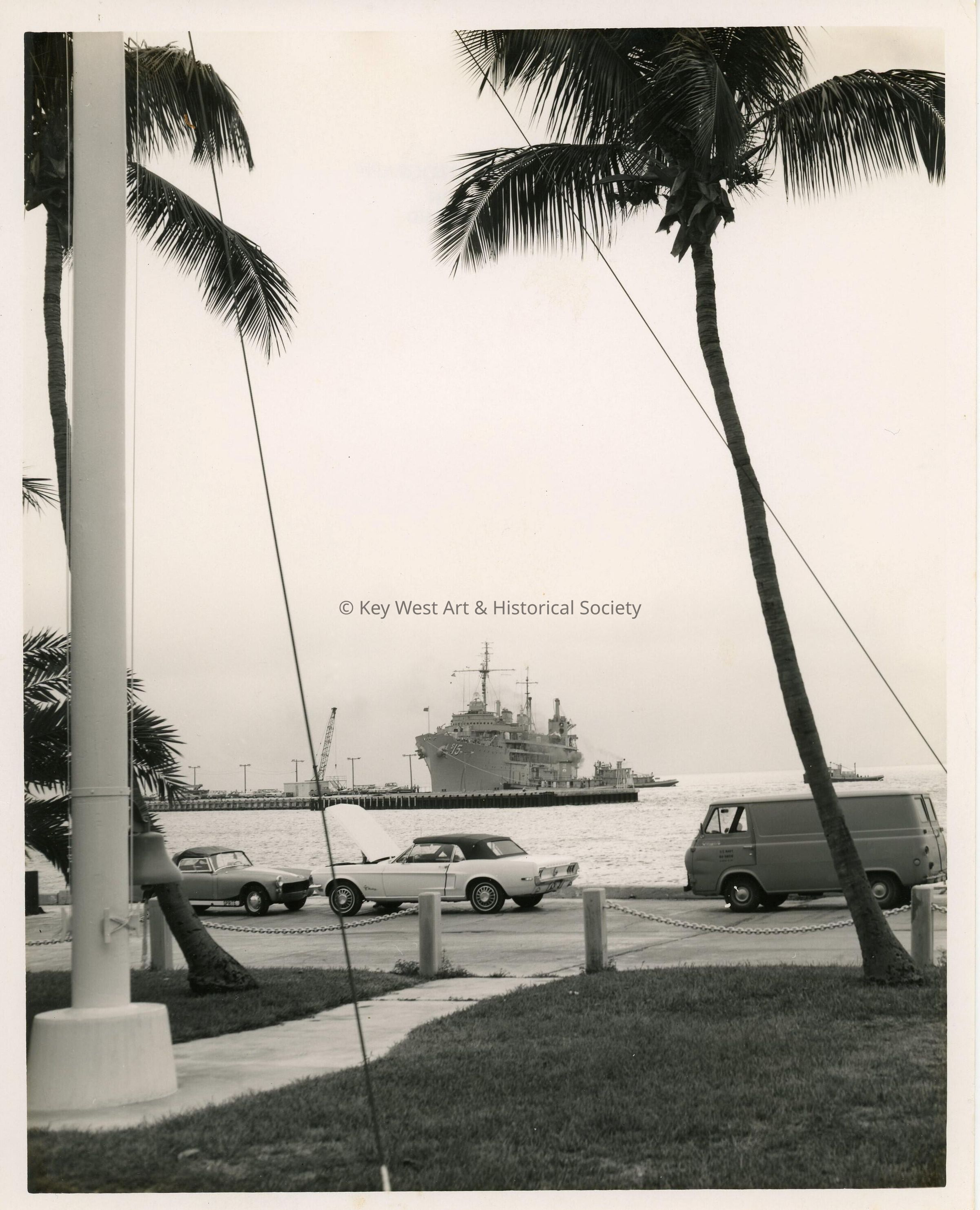 A military ship and a few cars parked