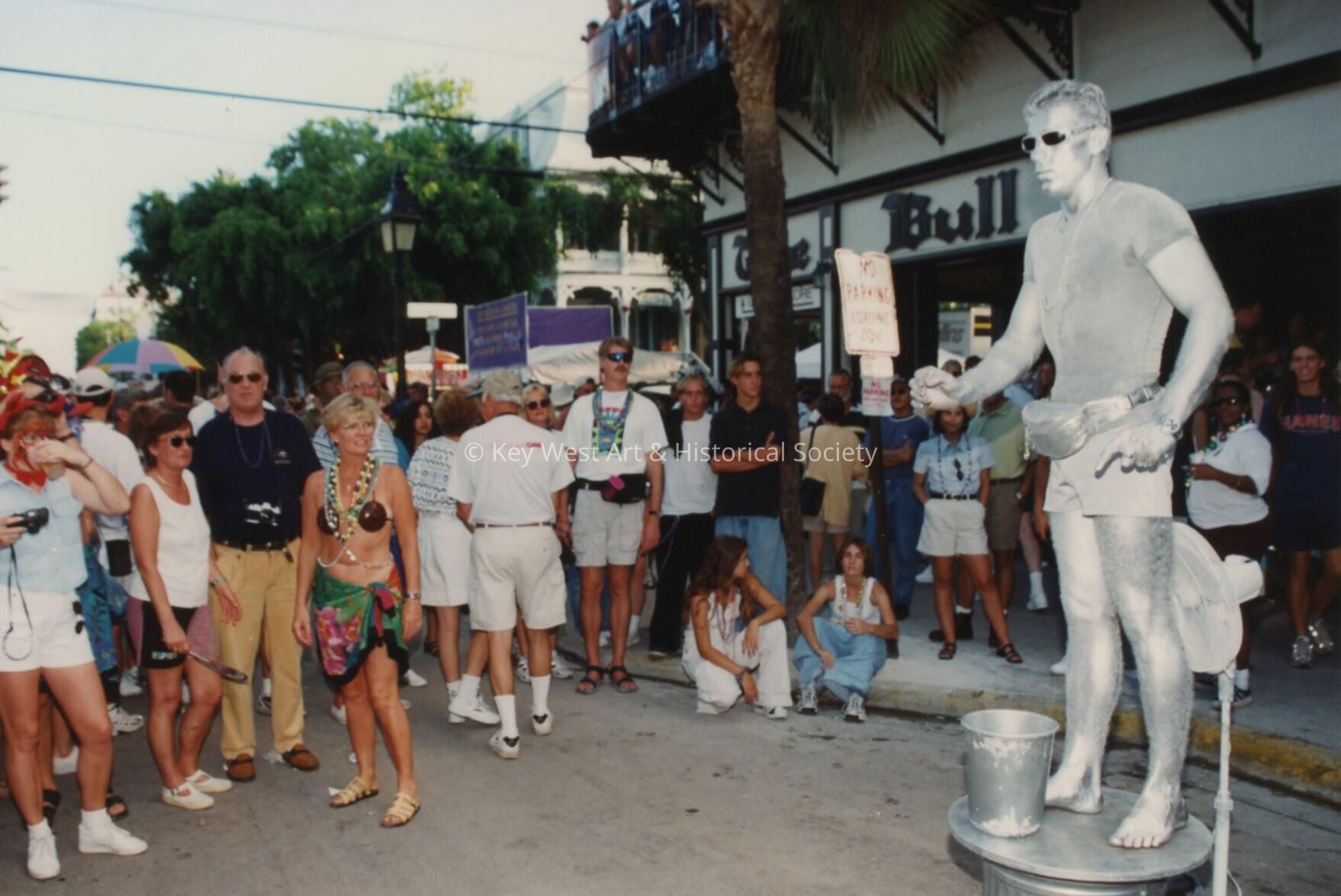 A group of unknown people standing around the Silver man in front of The Bu