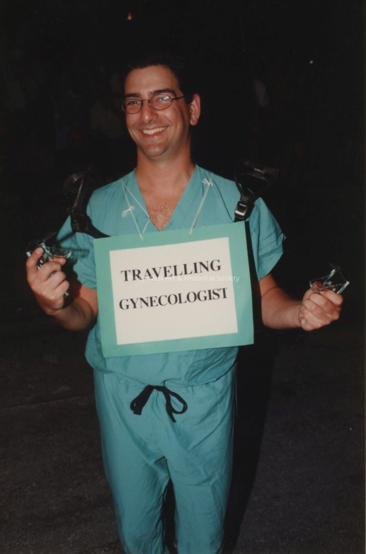 An unknown man dressed up, his costume reads traveling gyn.