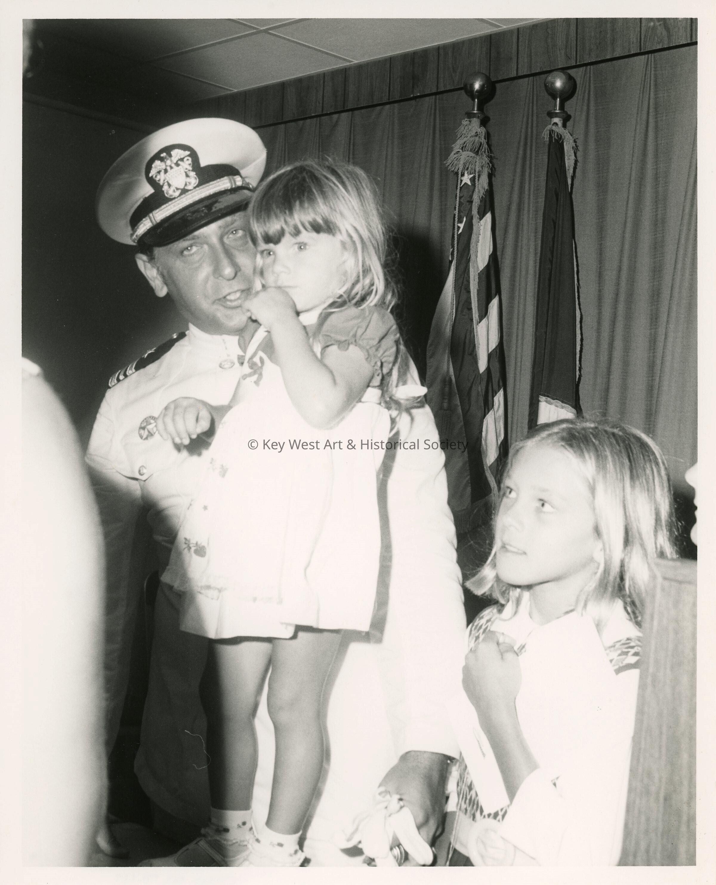 An unknown man in uniform with 2 kids
