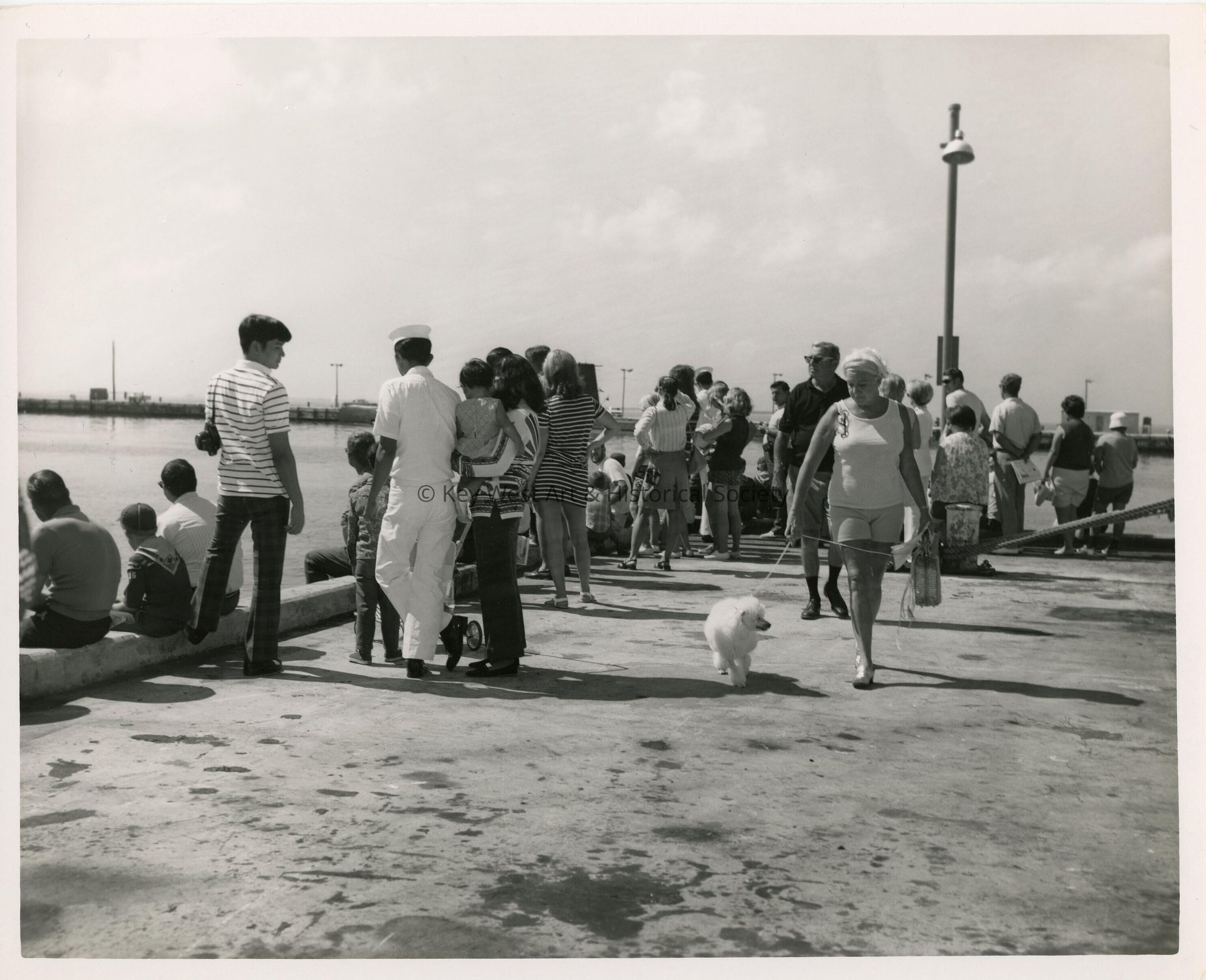A group of unknown people on a pier