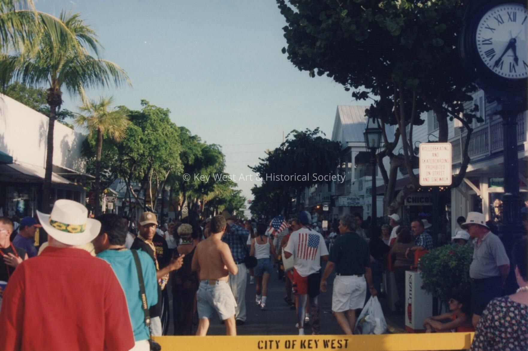 A group of people walking down Duval Street.